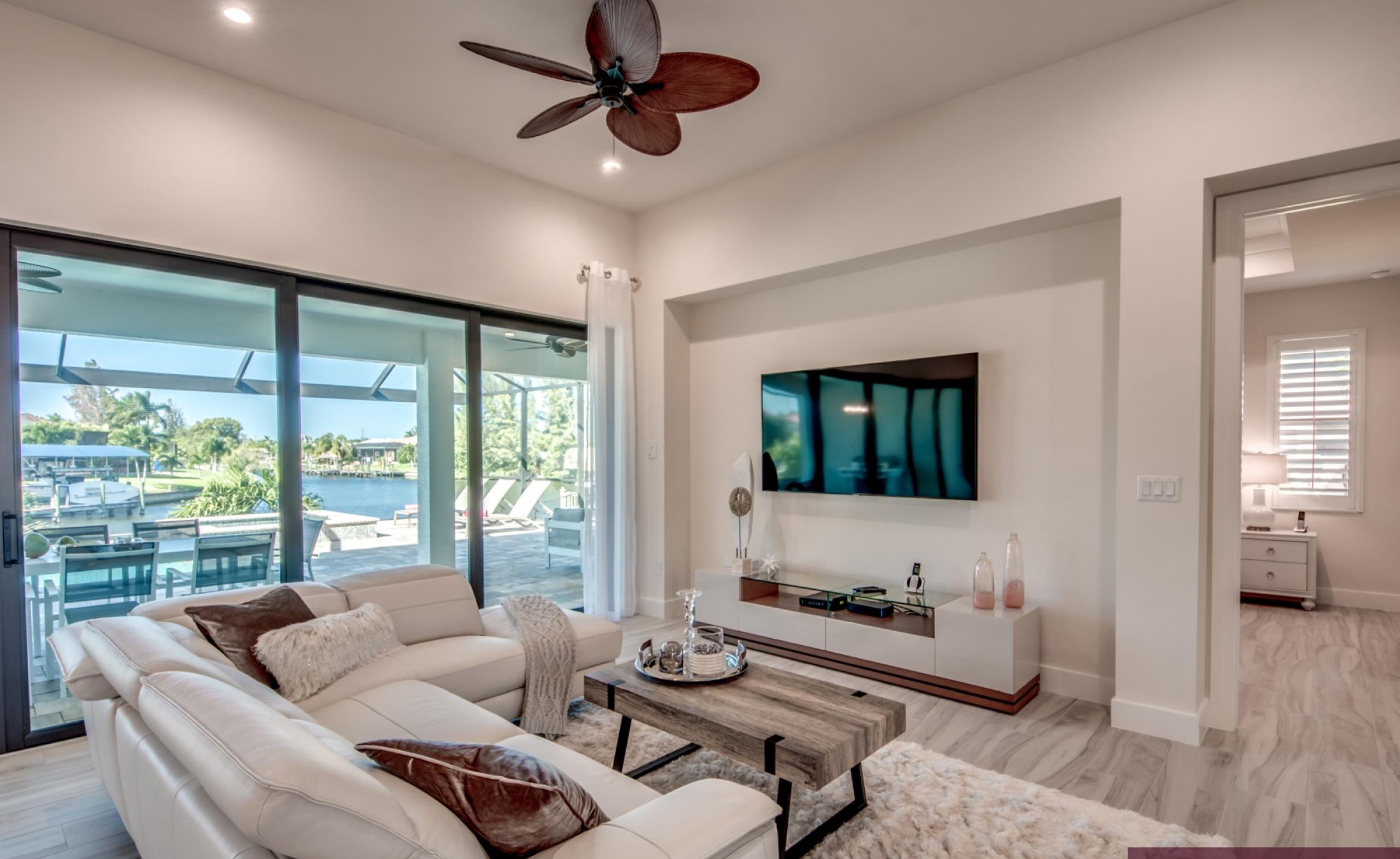 Poolbereich mit Spa und Blick auf den Kanal bei Sonnenuntergang.