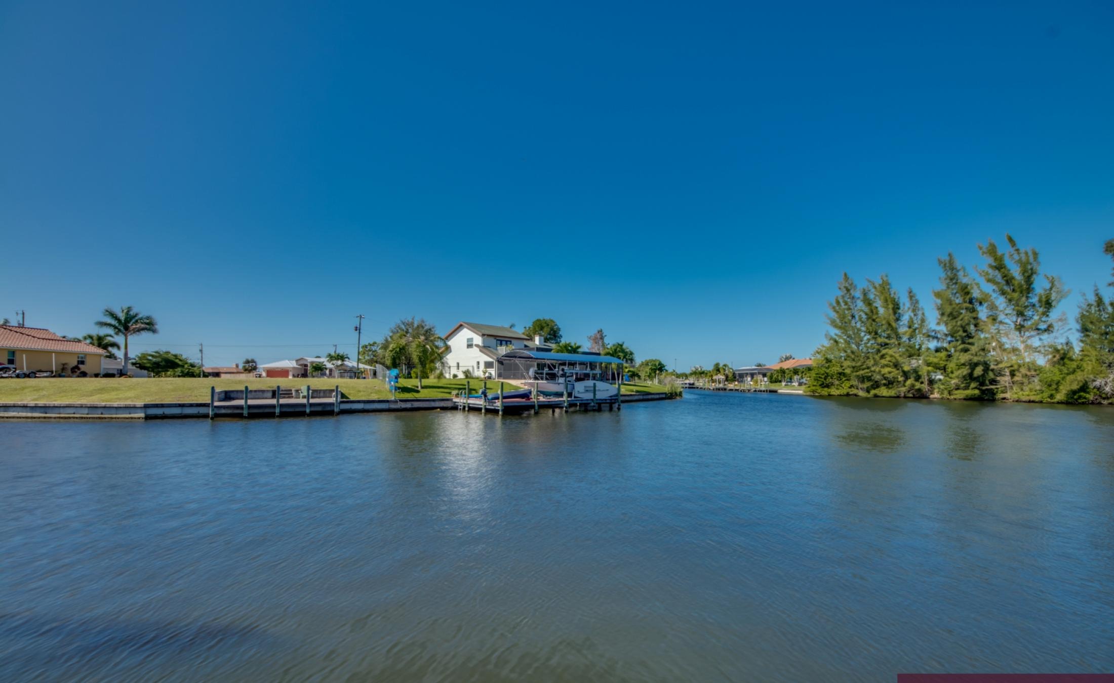 Pool- und Spa-Bereich am Kanal mit Bootsdock und Blick aufs Wasser.