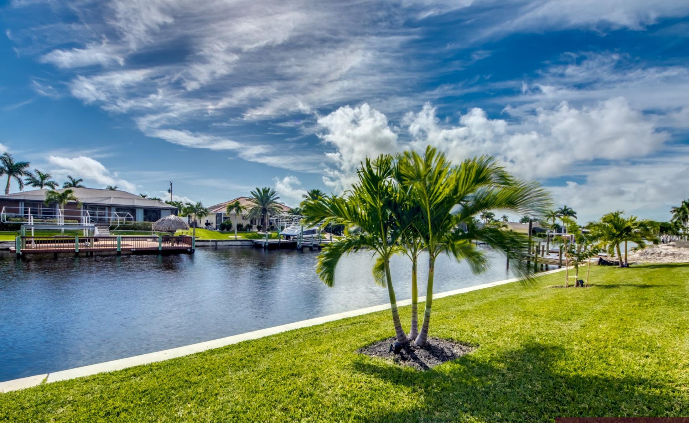 Außenbereich mit beheiztem Pool und Jacuzzi an der Uferlage.