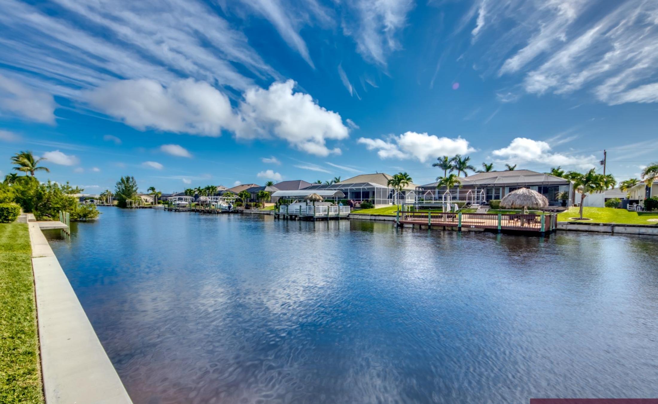 Moderner Pool- und Lanai-Bereich am Kanal mit Blick aufs Wasser.