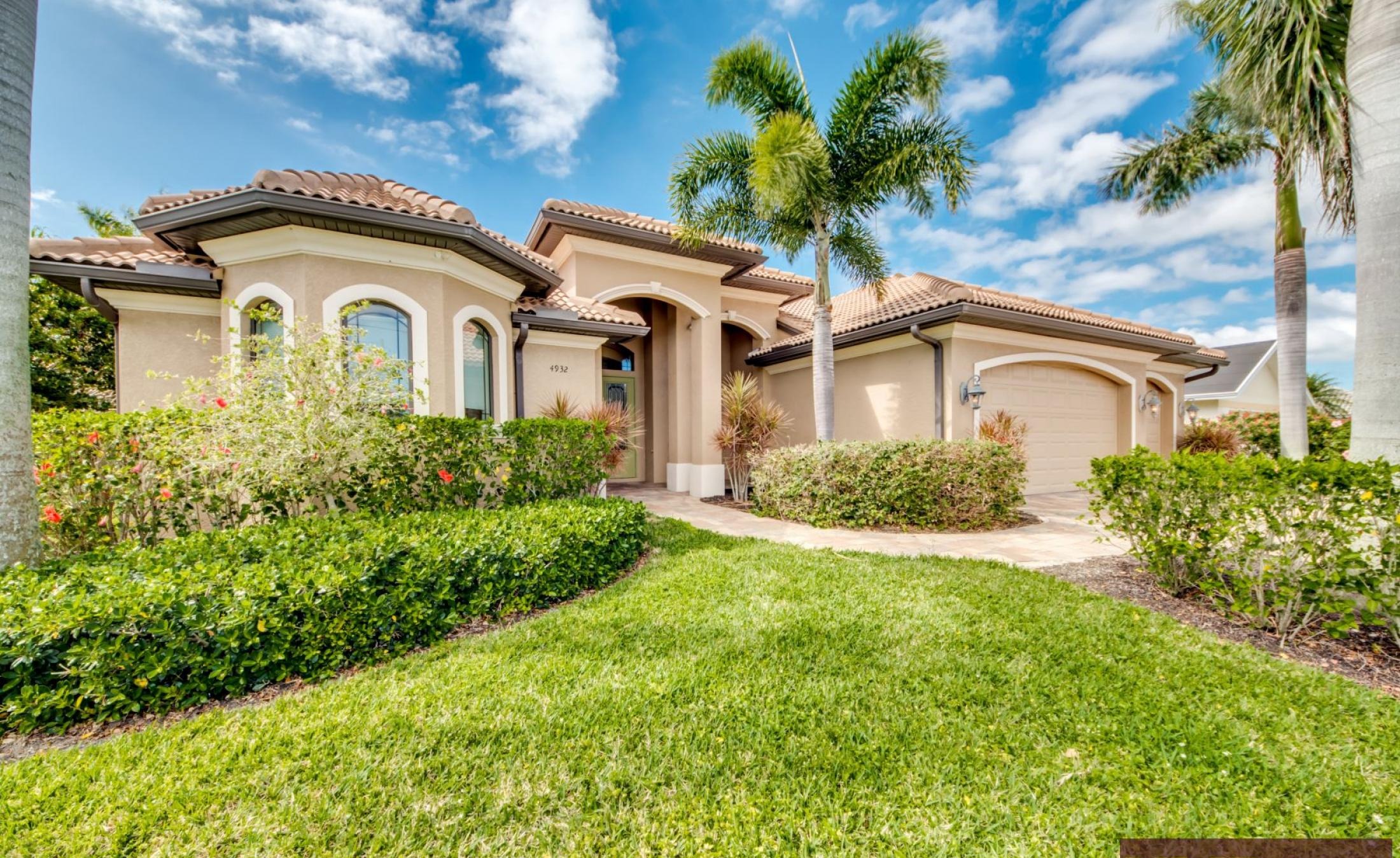 Westlich ausgerichtete Lanai mit beheiztem Pool, Spa und Blick auf den Kanal mit privatem Dock.