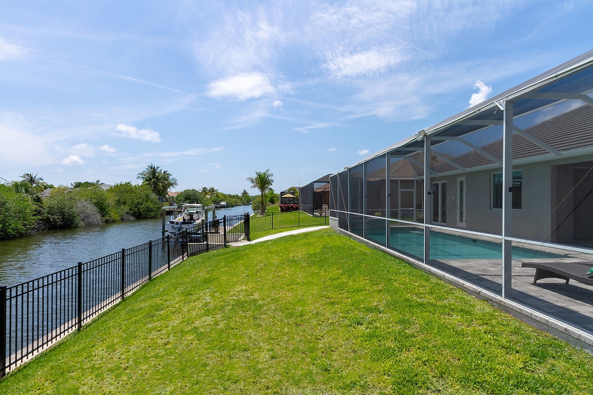 Südseitiger Poolbereich mit Whirlpool und Blick auf den Kanal mit privatem Dock.