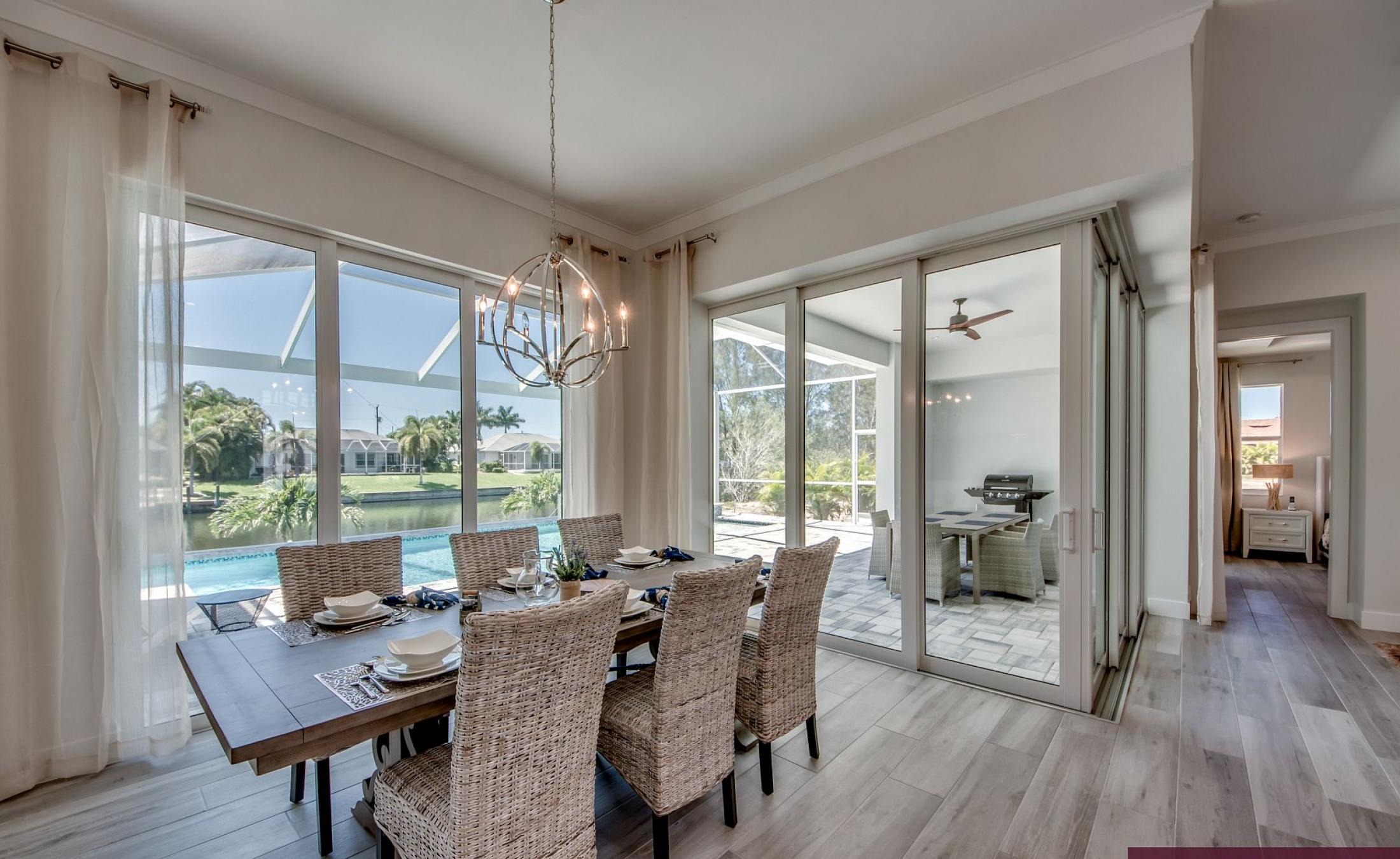 Sonniger Poolbereich am Kanal mit privatem Bootsdock und Blick aufs Wasser.