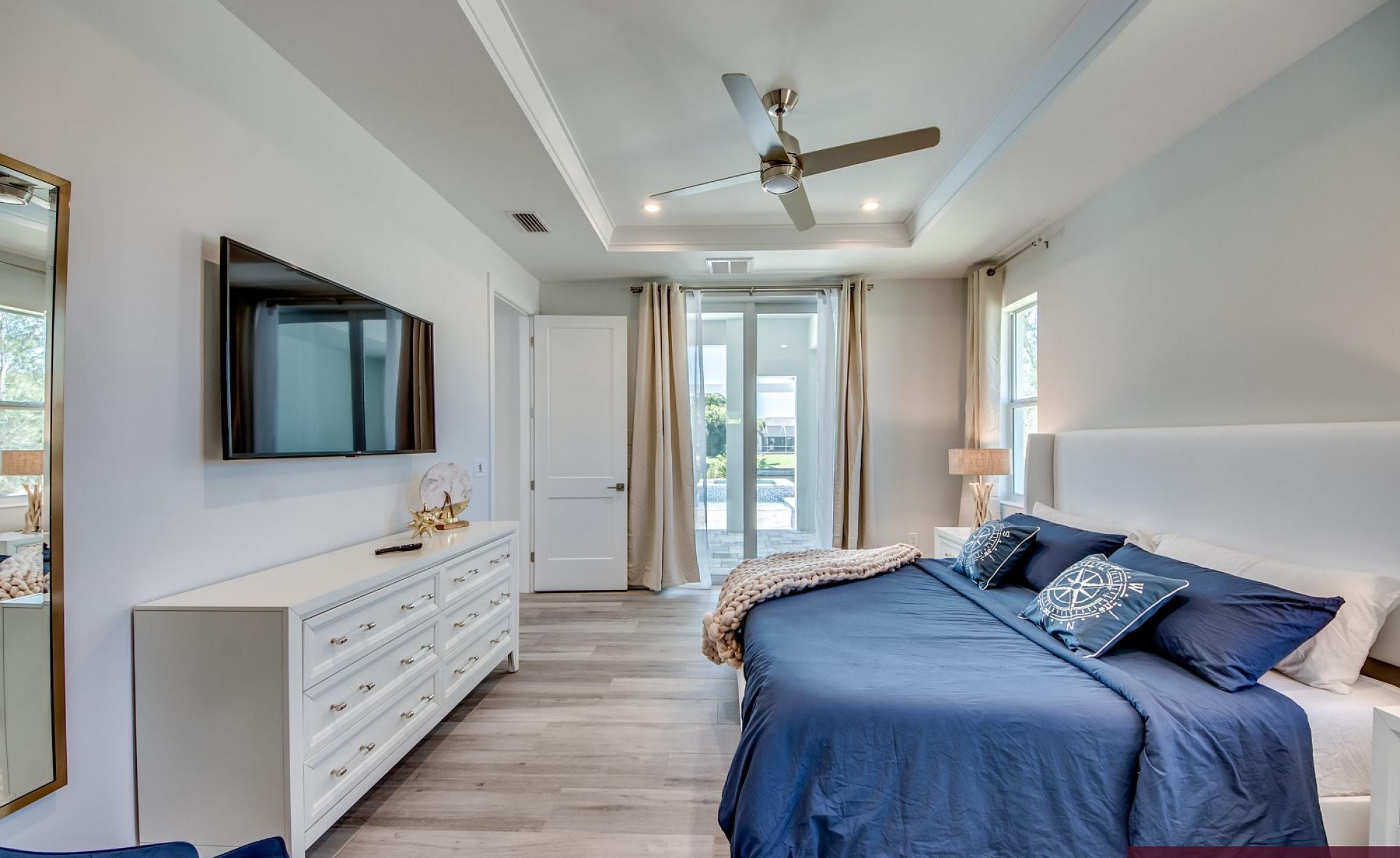 Sonniger Poolbereich am Kanal mit privatem Bootsdock und Blick aufs Wasser.