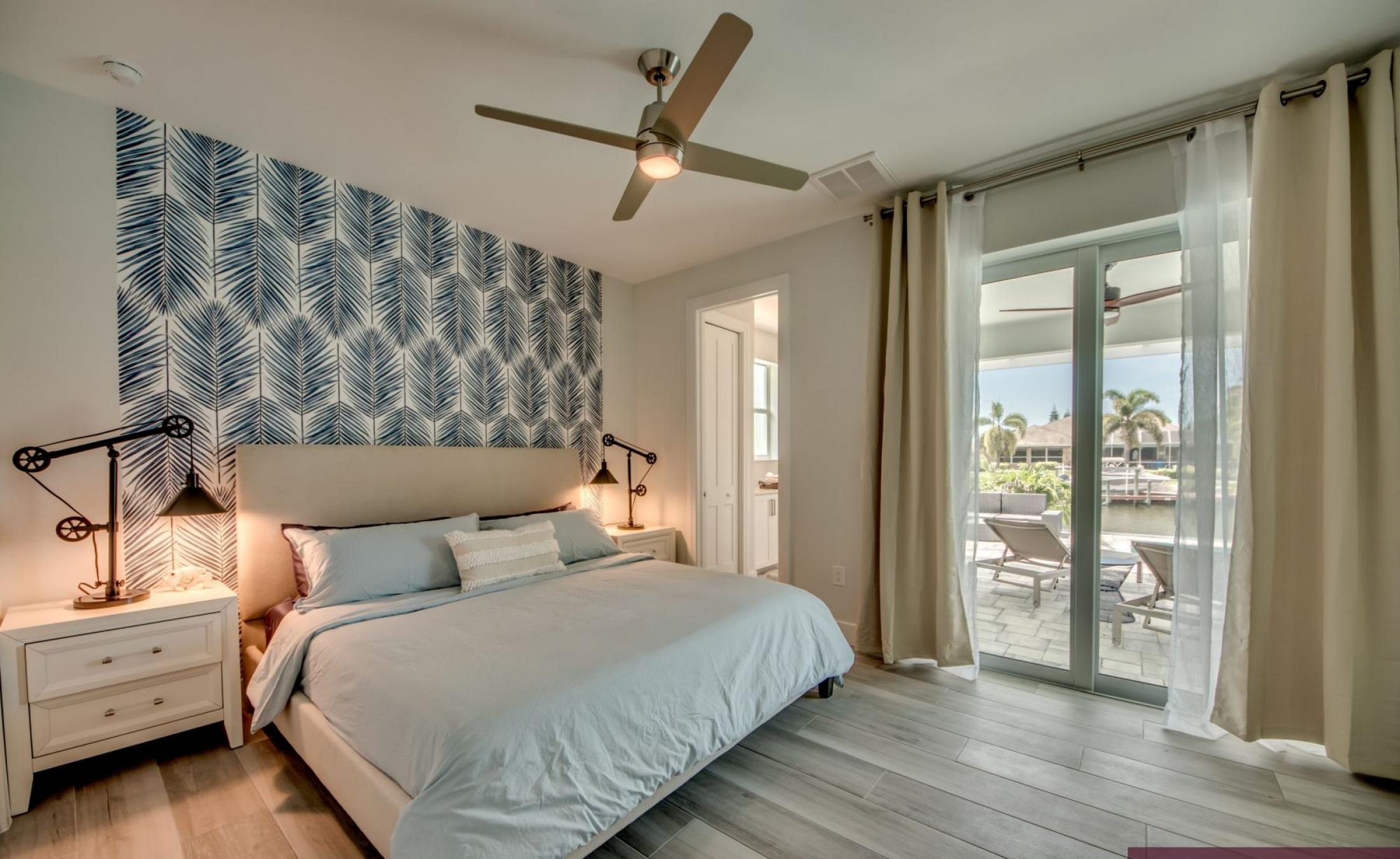 Sonniger Poolbereich am Kanal mit privatem Bootsdock und Blick aufs Wasser.