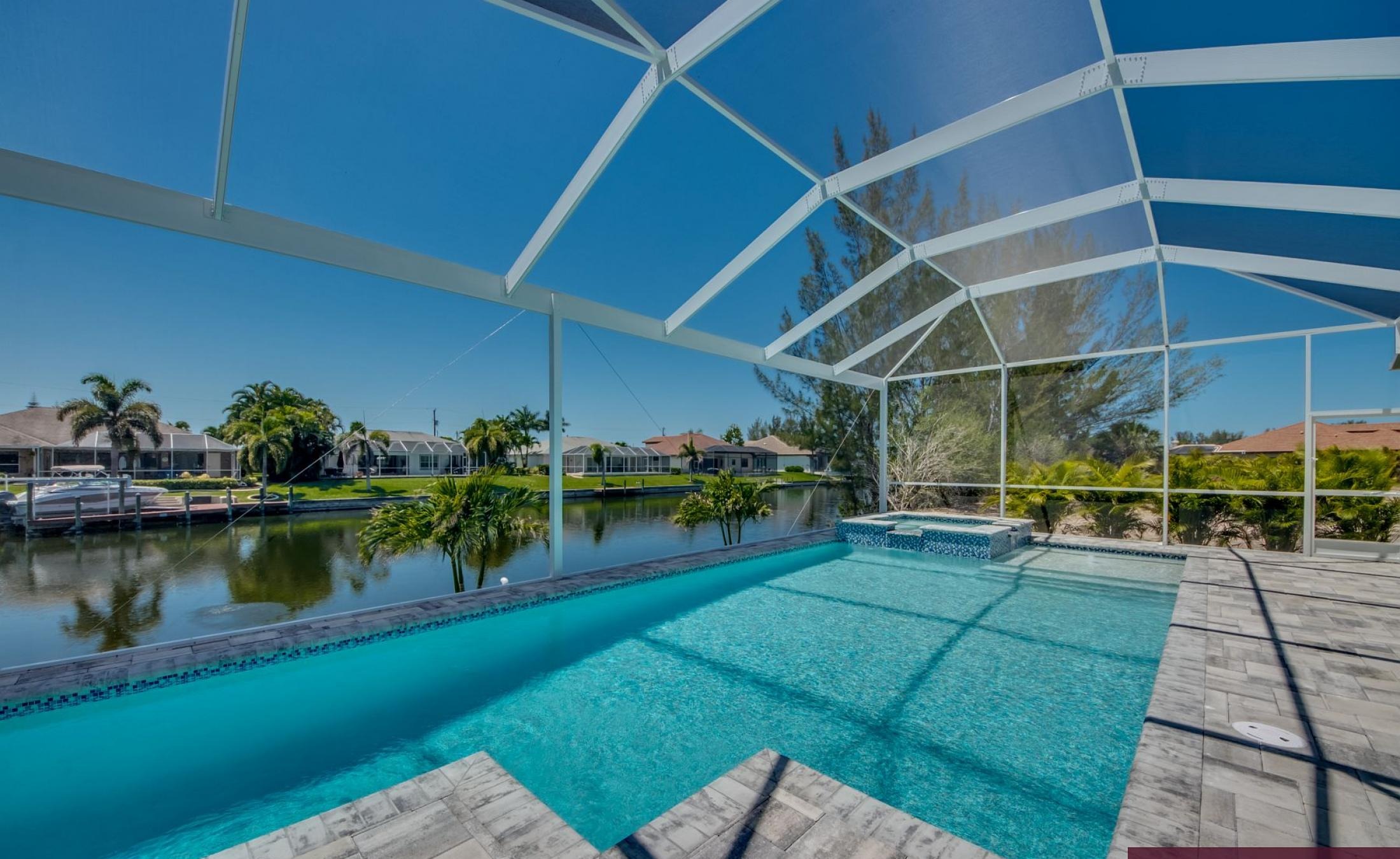 Südseitiger Pool- und Spa-Bereich am Kanal mit privatem Bootsdock.