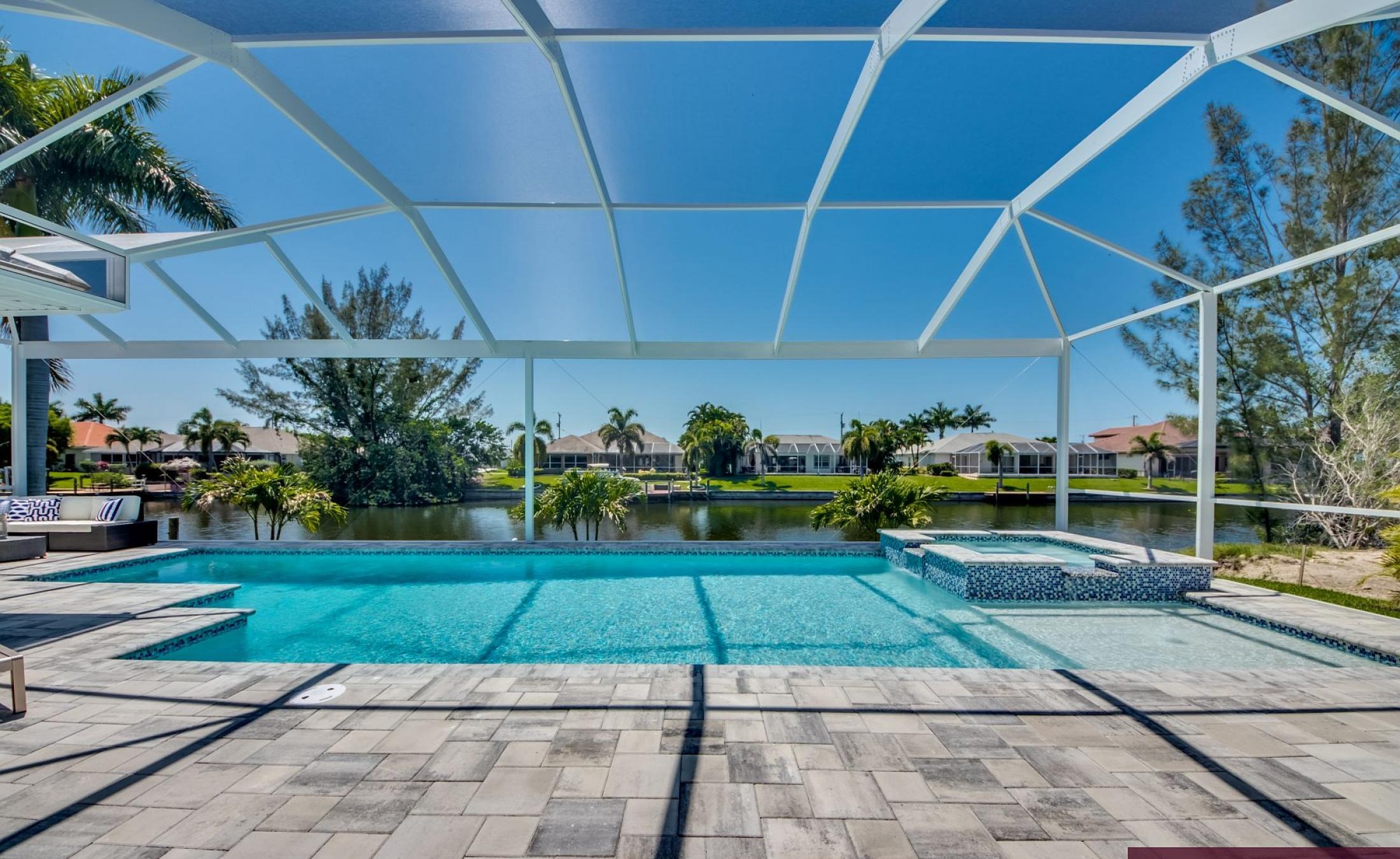 Beheizbarer Pool und Spa auf der Terrasse mit Blick auf den Kanal und privatem Bootsdock.