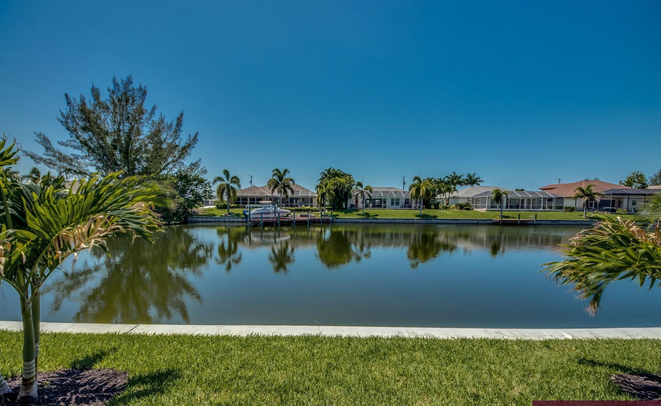 Südseitiger Poolbereich am Kanal mit privatem Bootsdock und Blick aufs Wasser.