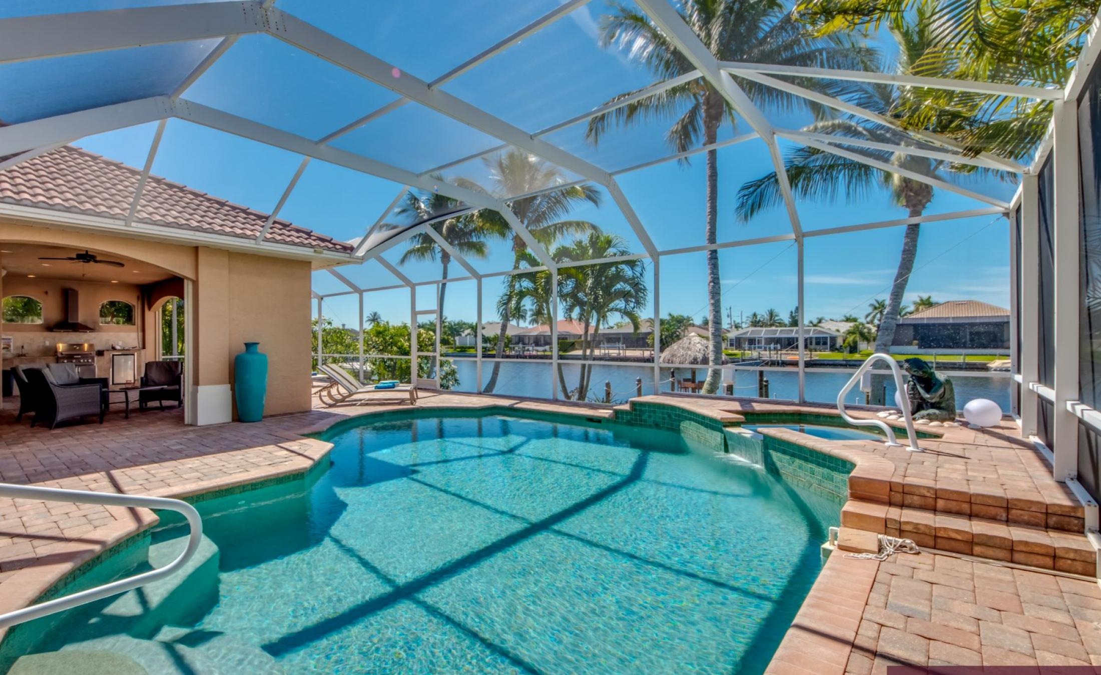 Außenbereich mit beheiztem Pool und Spa am Kanal mit privatem Dock.