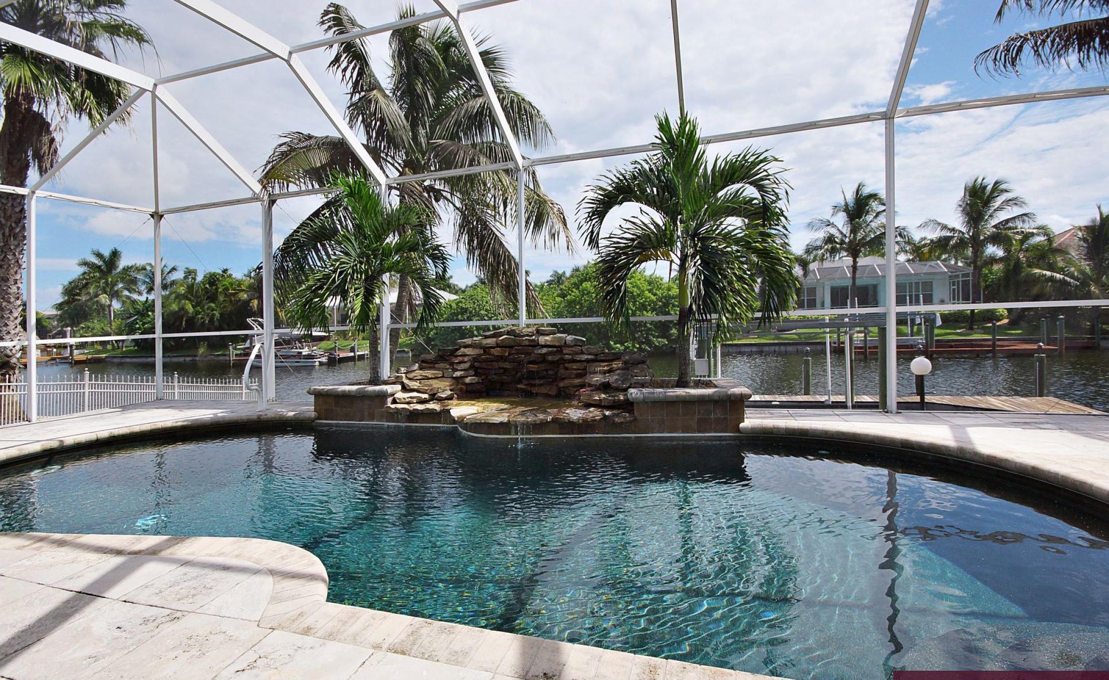 Elektrisch beheizter Pool mit Wasserfall und Blick auf den Kanal.