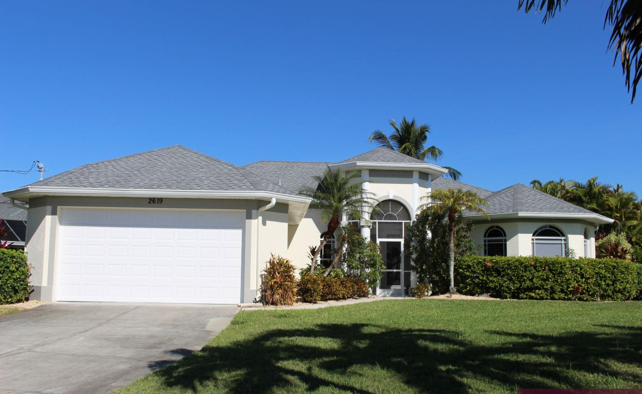 Außenansicht der Villa in Cape Coral mit beheiztem Pool am Wasser und privatem Bootsdock.
