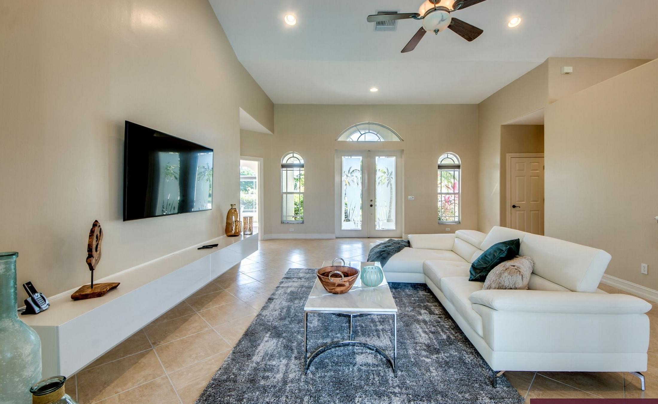 Beheizter Pool mit Sonnenschirm und Strandstühlen am Wasserkanal.