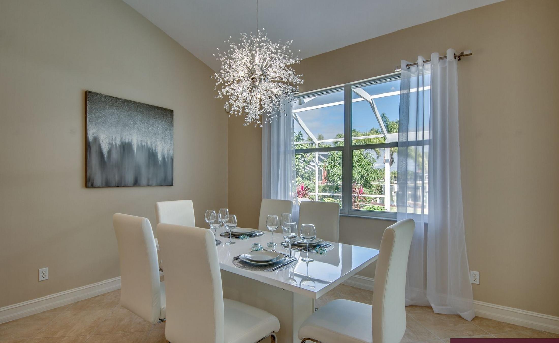 Elektrisch beheizter Pool mit Sonnenschirm und Strandstühlen am Wasserkanal.