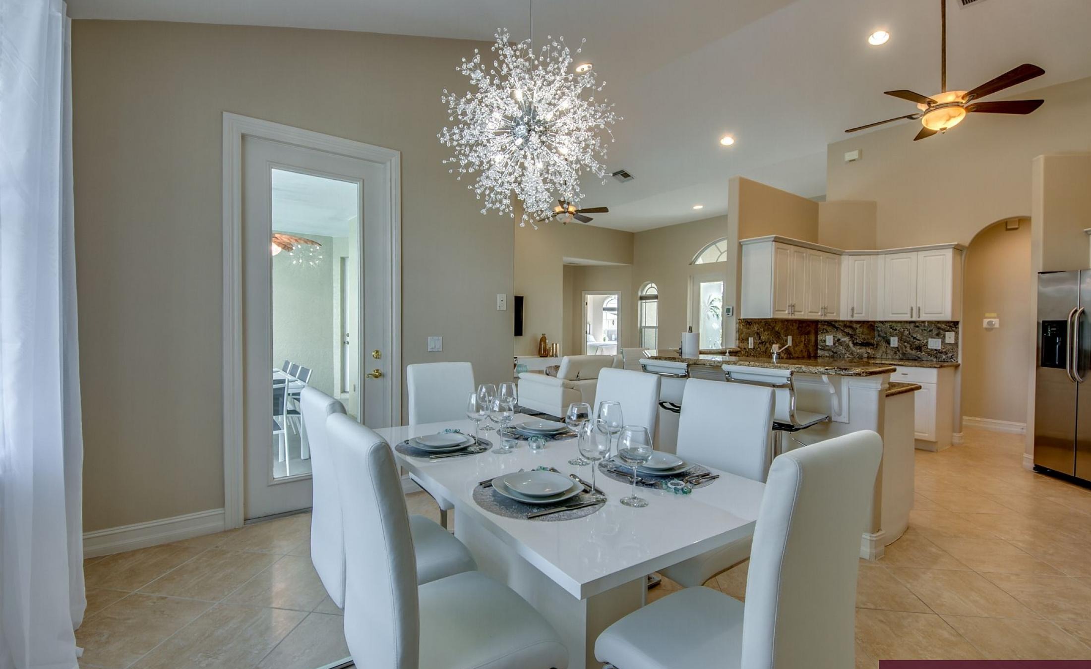 Beheizter Pool mit Sonnenschirm und Strandstühlen am Wasser.