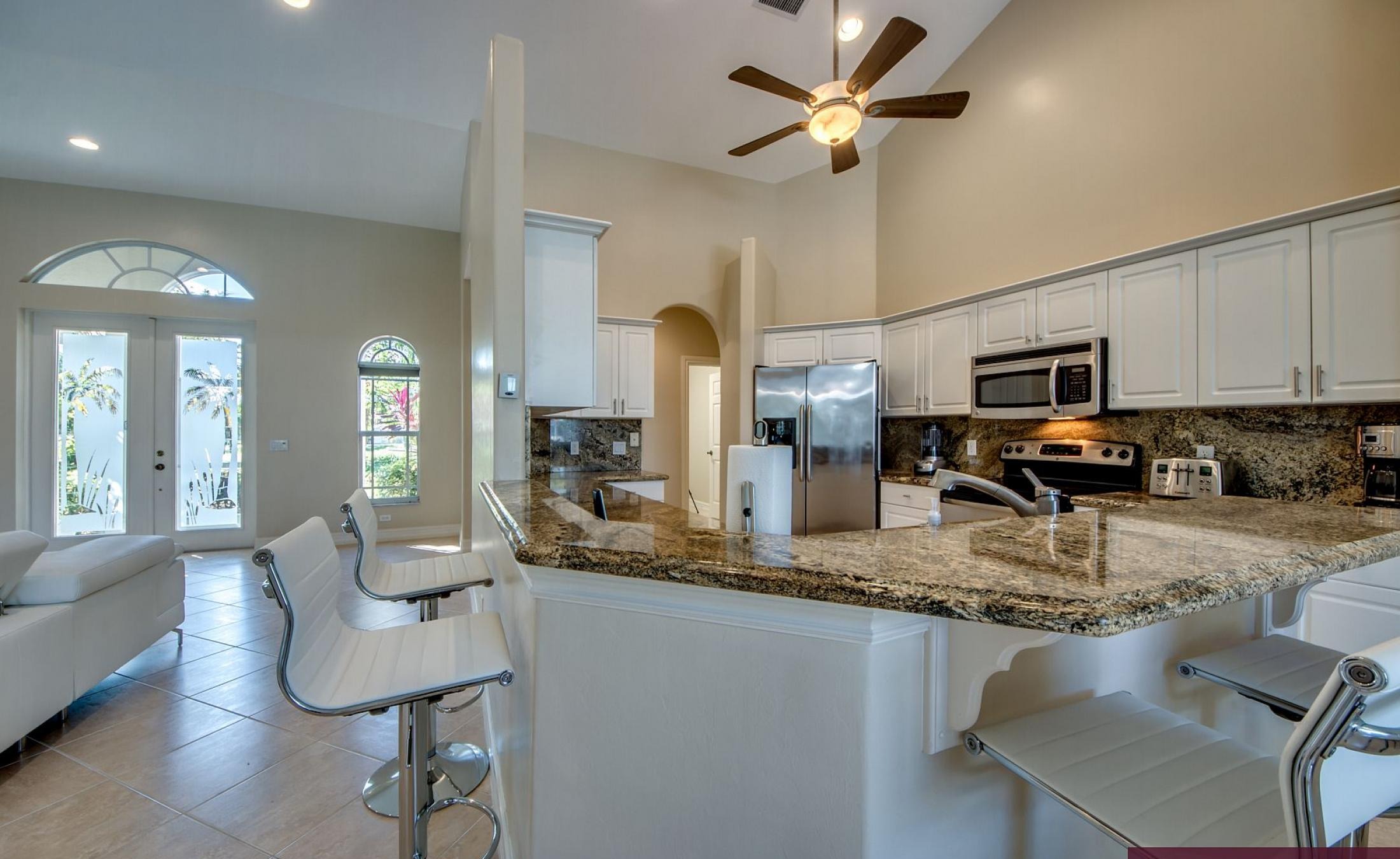 Beheizter Pool mit Sonnenschirm und Strandstühlen am Wasserkanal.