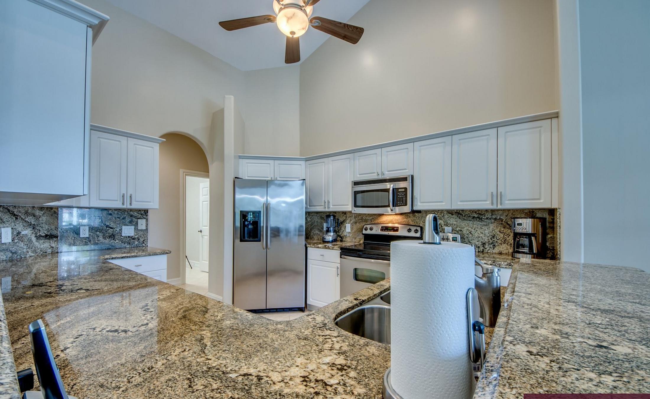 Beheizter Pool mit Sonnenschirm und Strandstühlen am Wasserkanal.