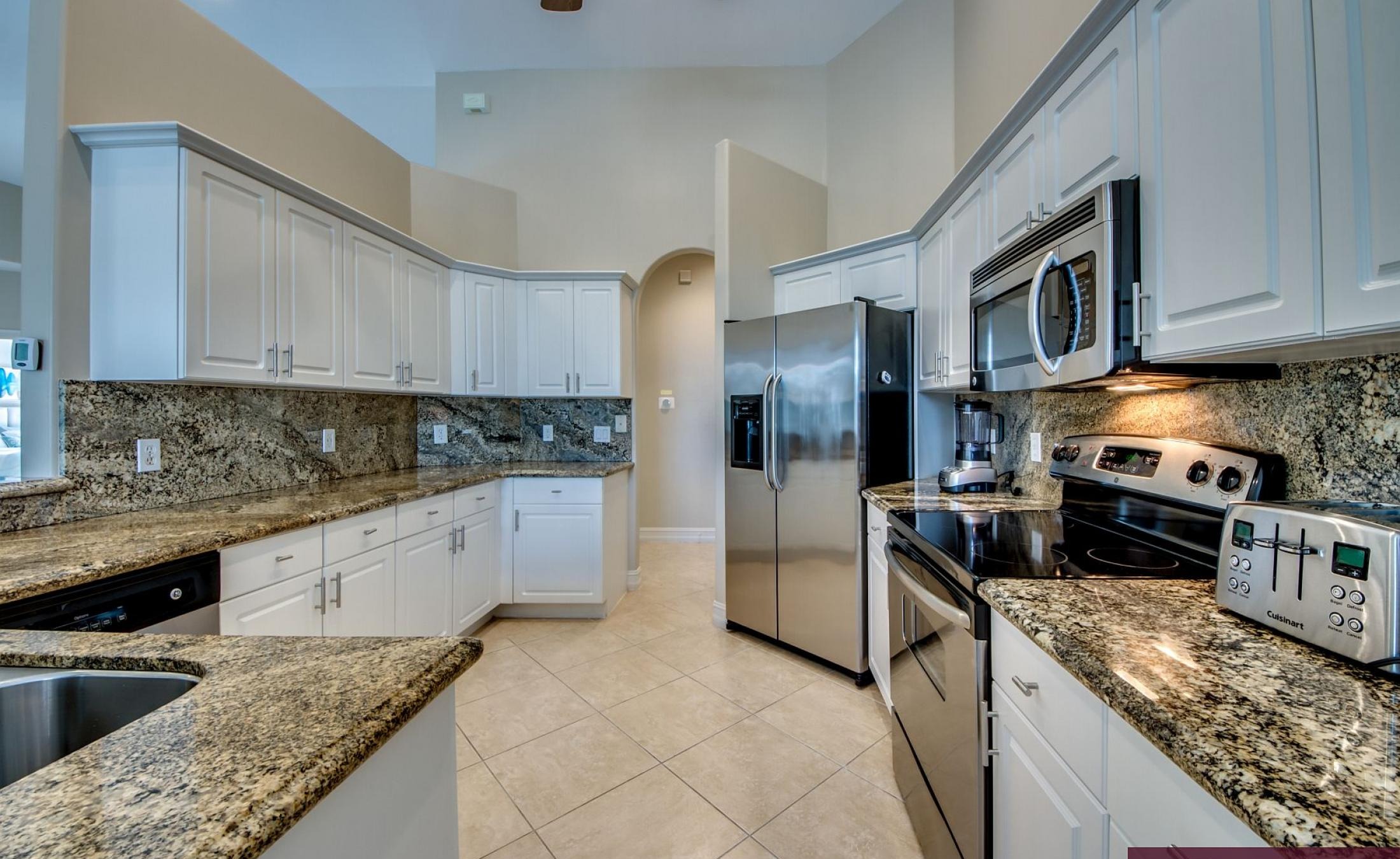 Beheizter Pool mit Sonnenschirm und Strandstühlen am Wasserkanal.