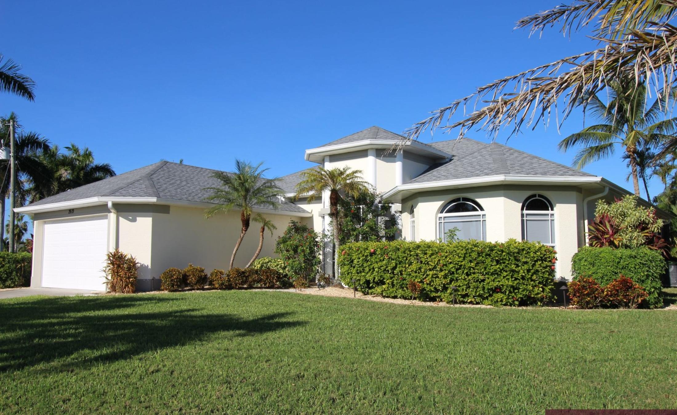 Beheizter Pool mit Liegestühlen am Wasserkanal und privatem Bootsdock.