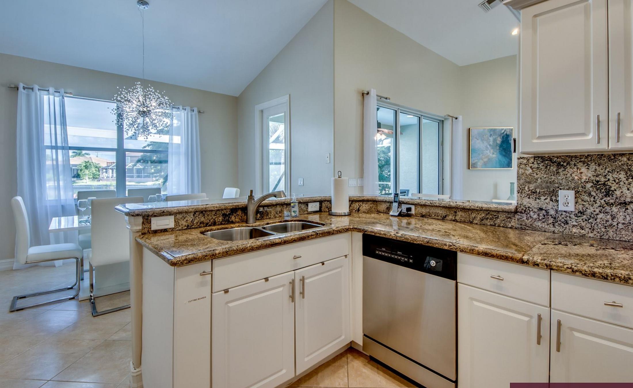 Beheizter Pool mit Sonnenschirm und Strandstühlen am Wasserkanal.