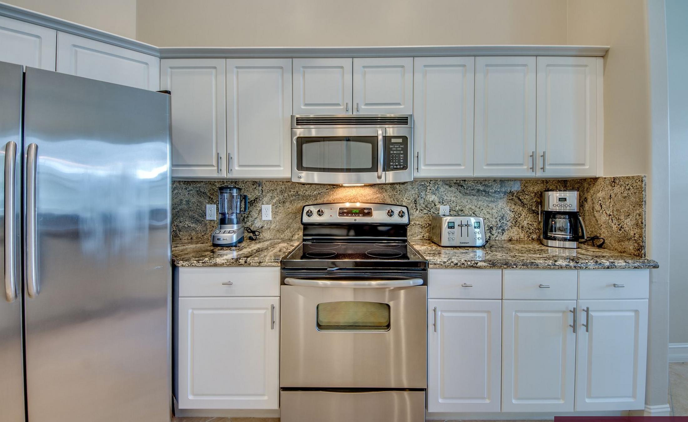 Elektrisch beheizter Pool mit Sonnenschirm und Strandstühlen am Wasserkanal.