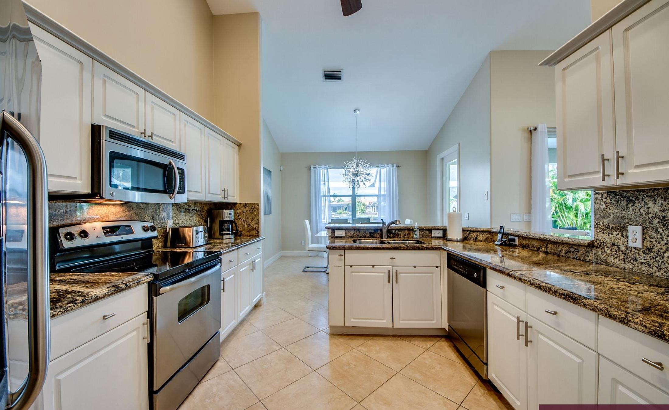 Elektrisch beheizter Pool mit Sonnenschirm und Strandstühlen am Wasser.