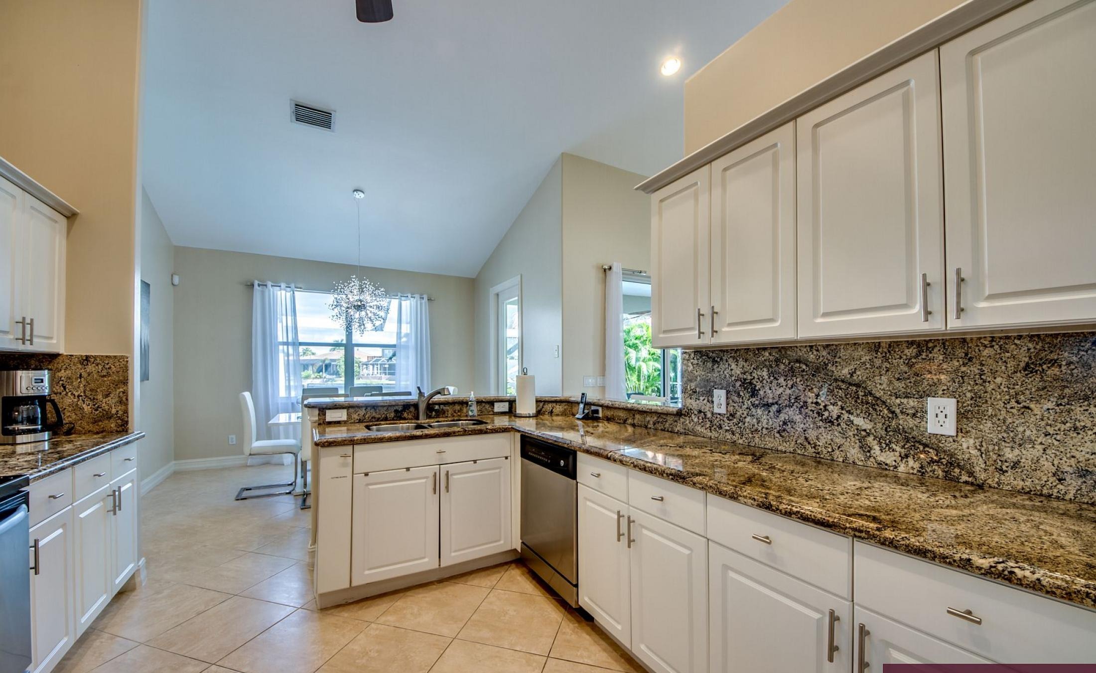 Beheizter Pool mit Sonnenschirm und Strandstühlen am Wasserkanal.