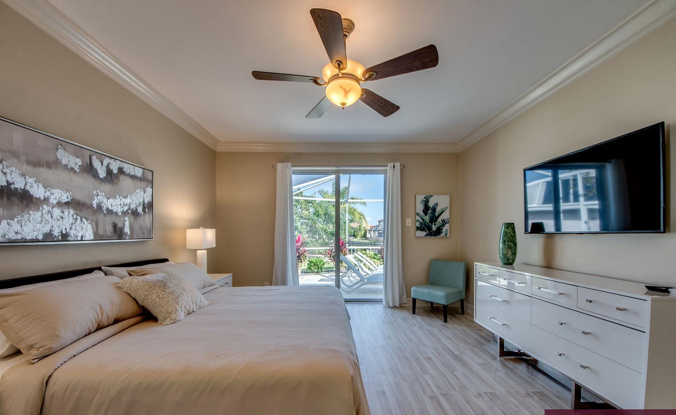 Beheizter Pool mit Sonnenschirm und Strandstühlen am Wasserkanal.