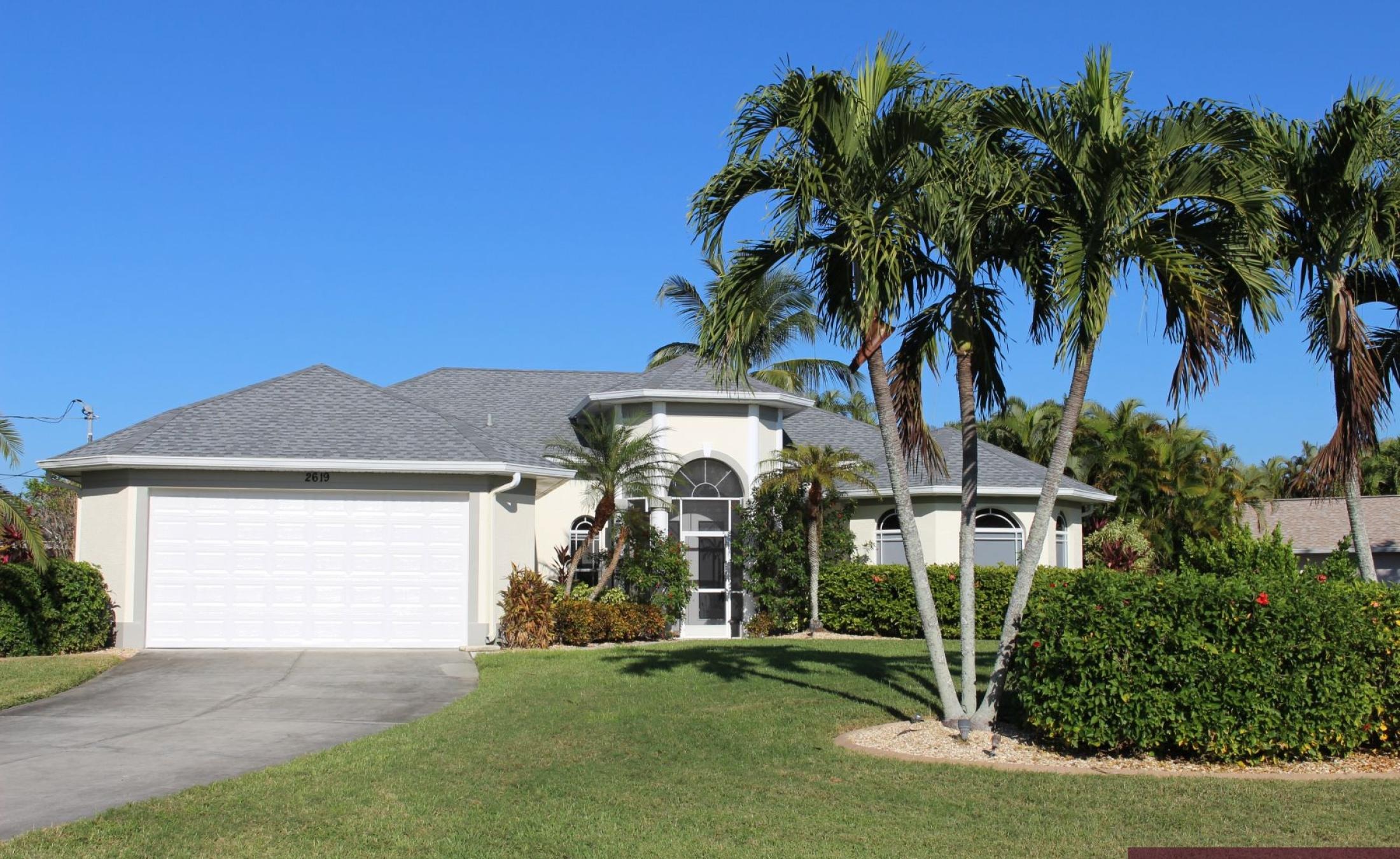 Elektrisch beheizter Pool mit Sonnenschirm und Strandstühlen am Wasserkanal.