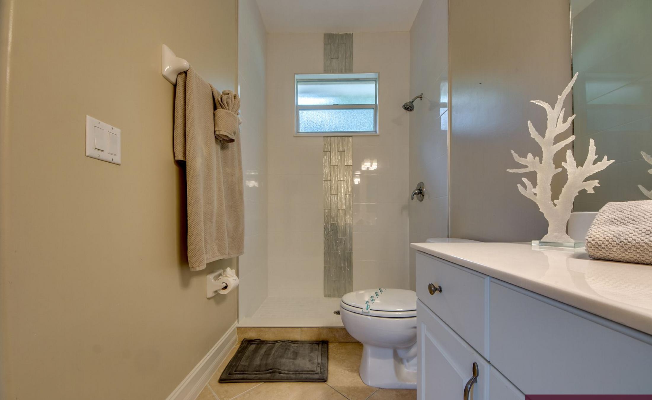 Elektrisch beheizter Pool mit Sonnenschirm und Strandstühlen am Wasserkanal.