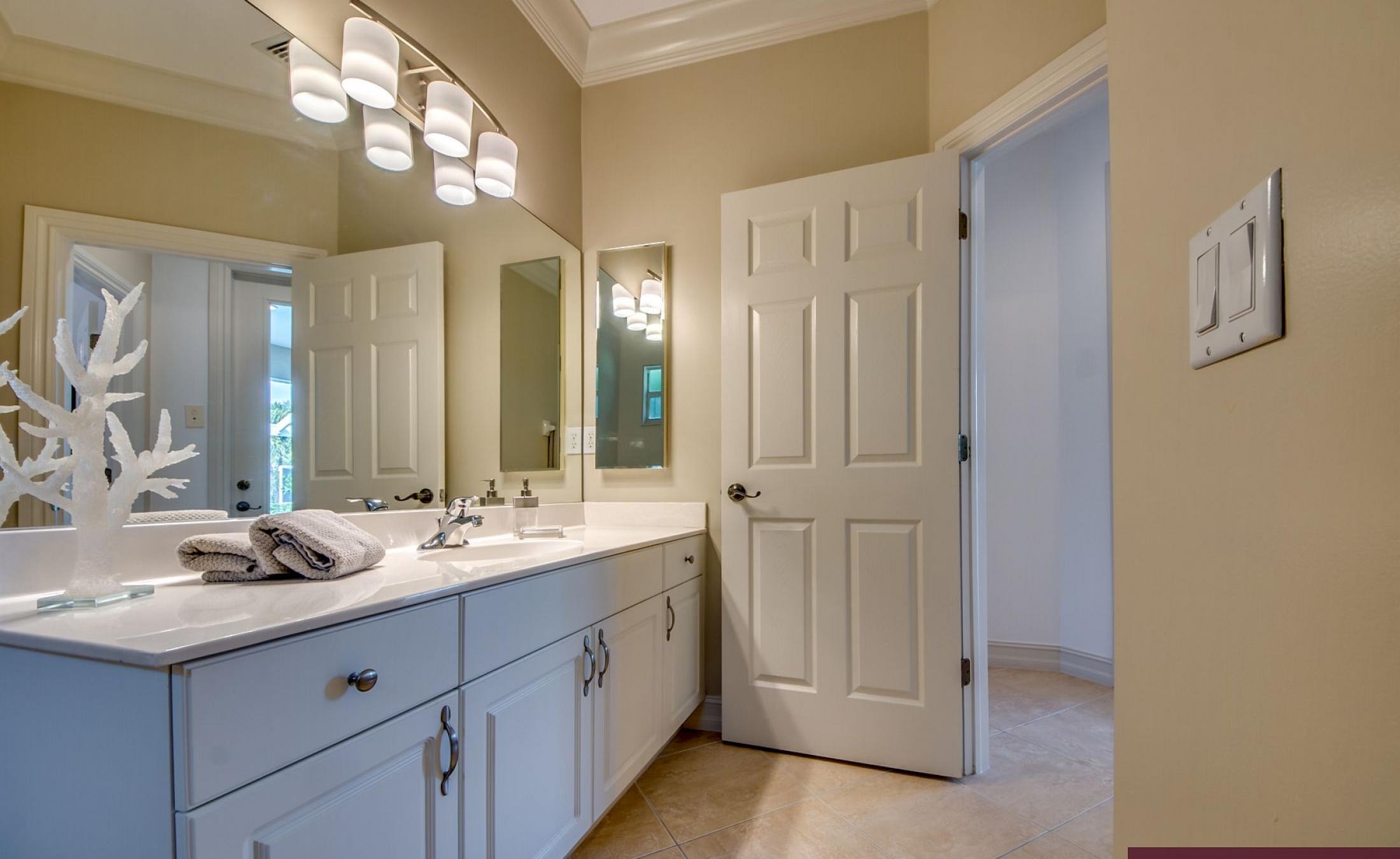 Beheizter Pool mit Sonnenschirm und Strandstühlen am Wasserkanal.