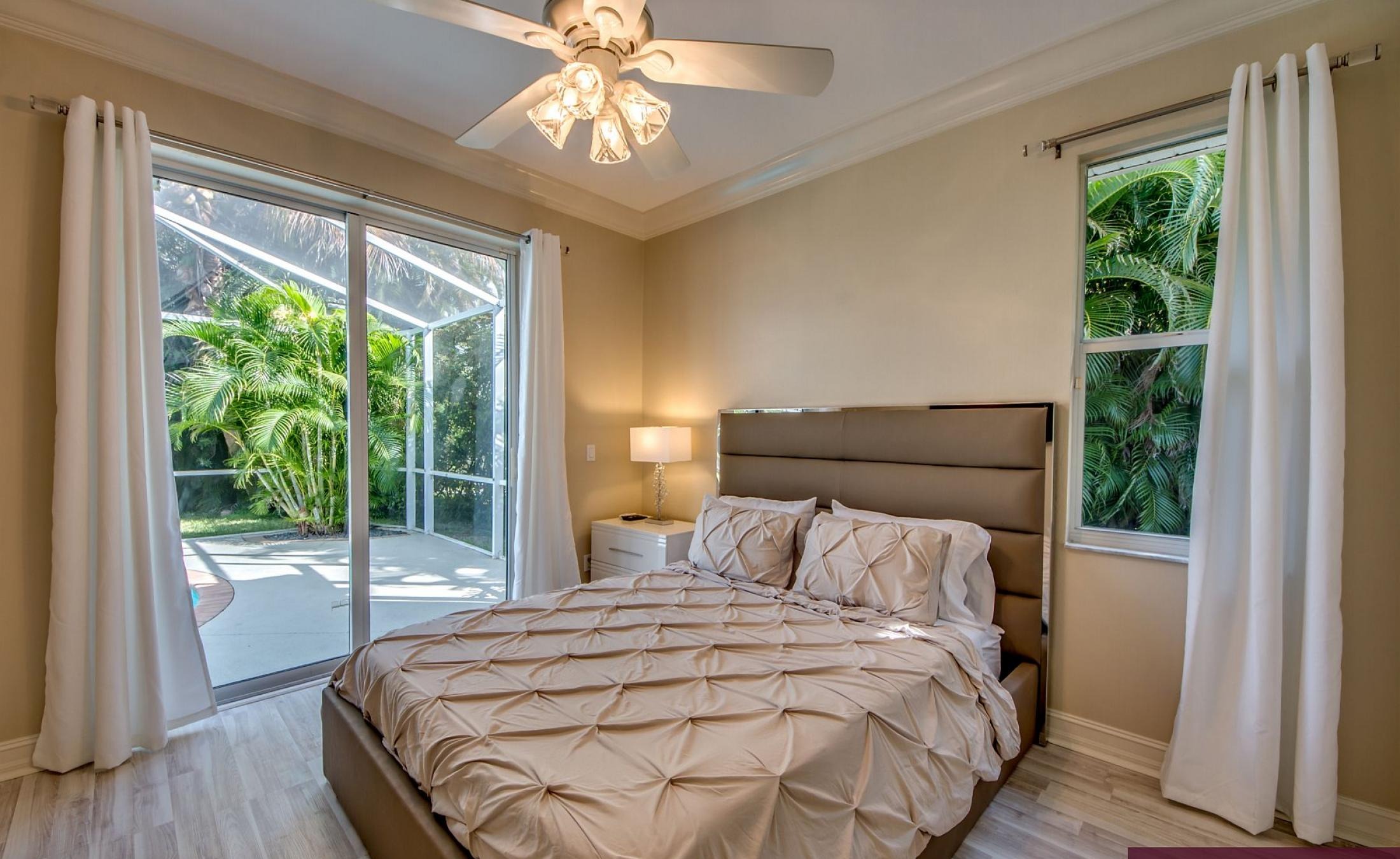 Elektrisch beheizter Pool mit Sonnenschirm und Strandstühlen am Wasserkanal.