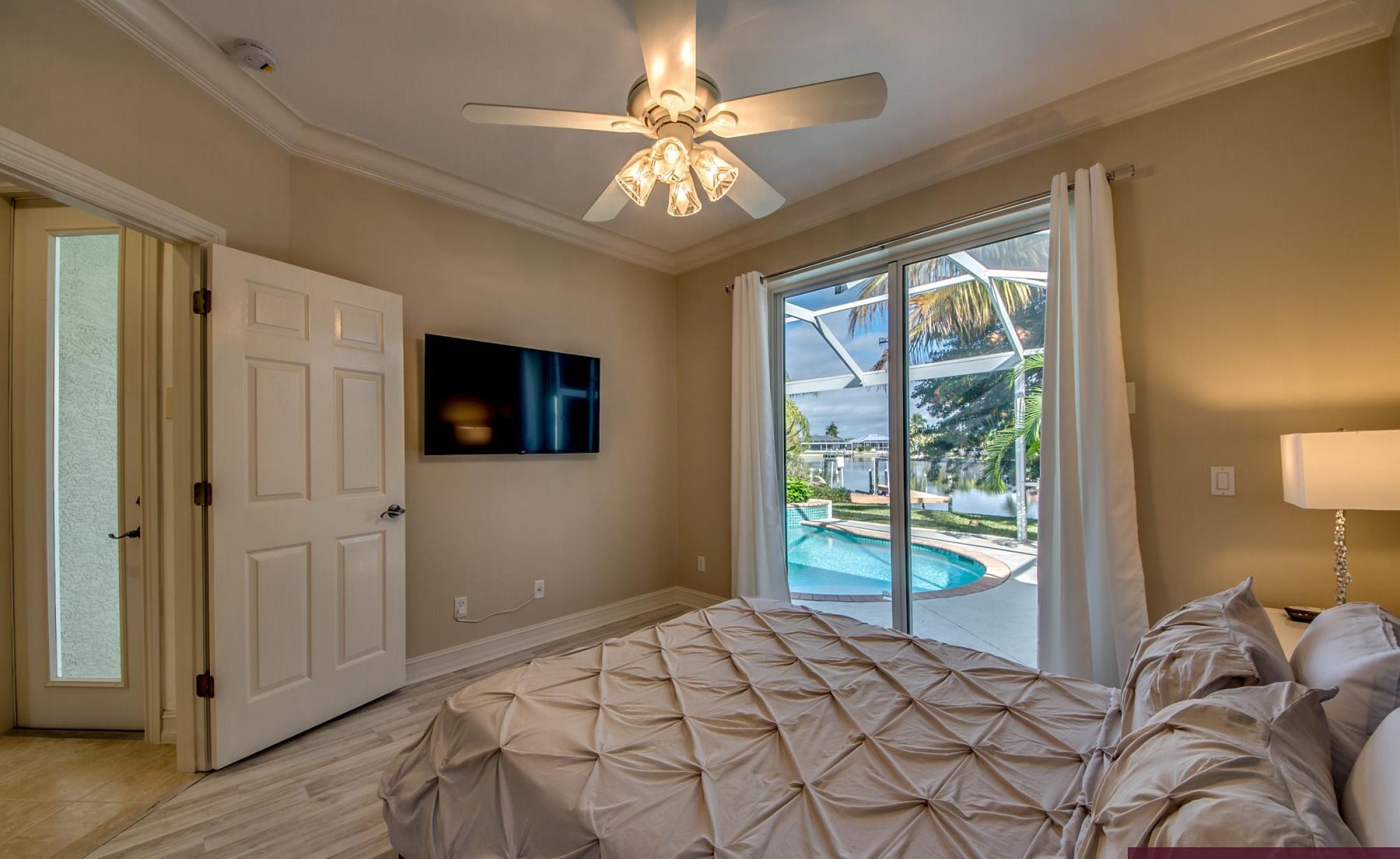 Beheizter Pool mit Sonnenschirm und Strandstühlen am Wasserkanal.