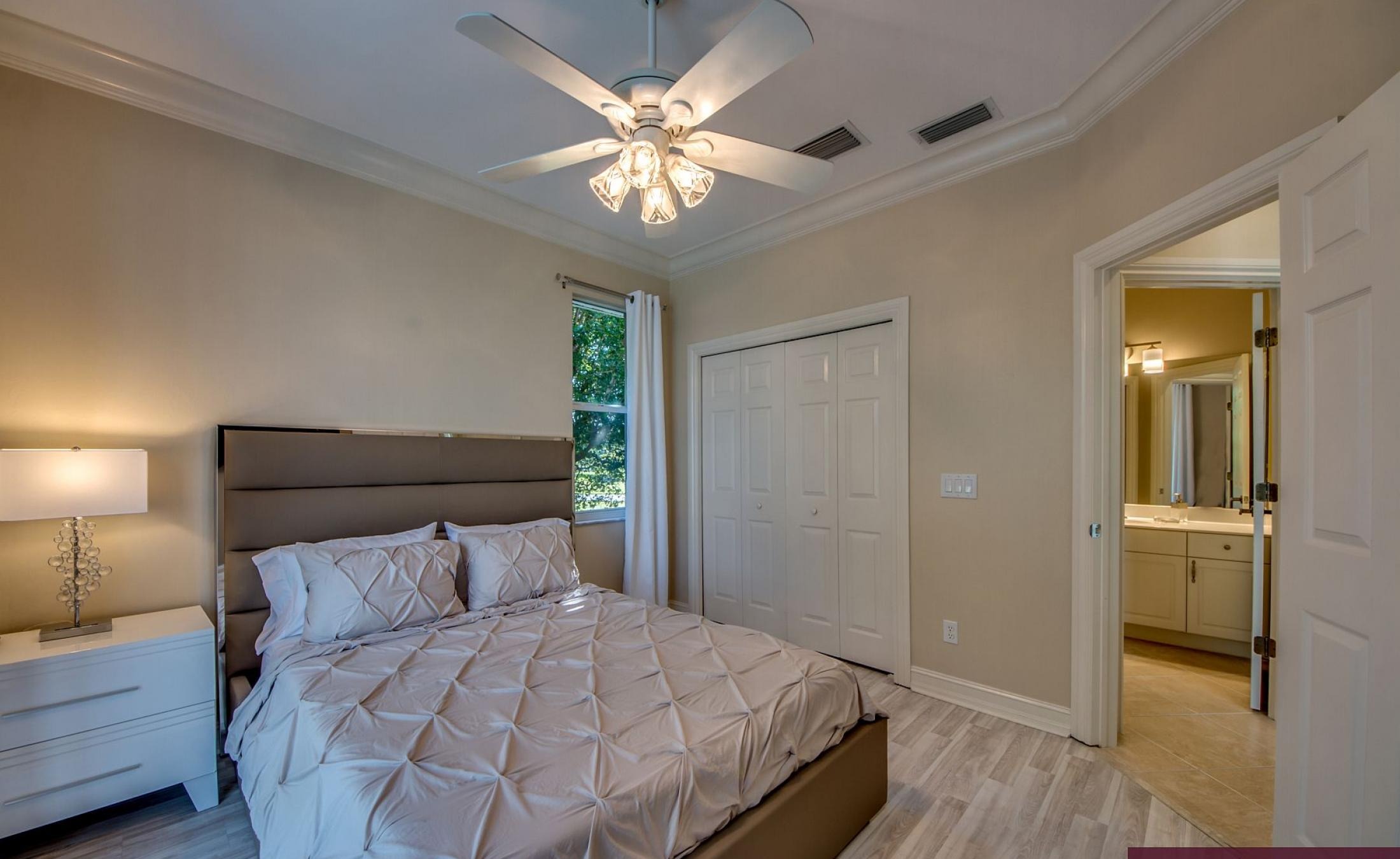 Elektrisch beheizter Pool mit Sonnenschirm und Strandstühlen am Wasser.