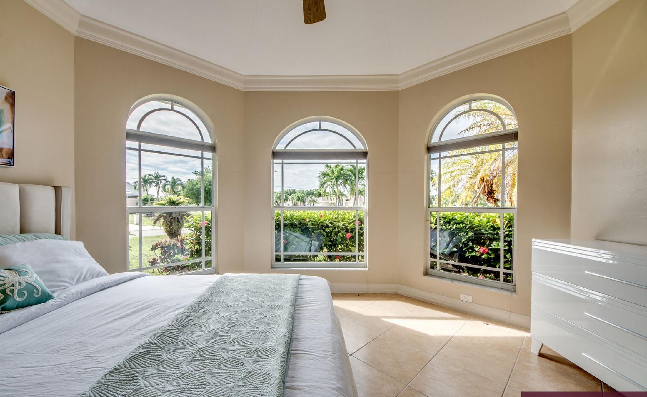 Beheizter Pool mit Sonnenschirm und Strandstühlen am Wasserkanal.