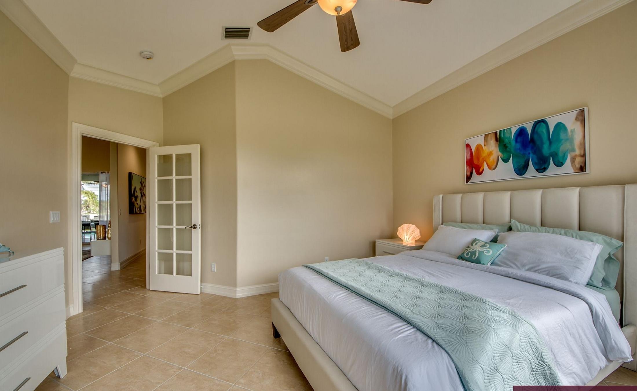 Elektrisch beheizter Pool mit Sonnenschirm und Strandstühlen am Wasserkanal.