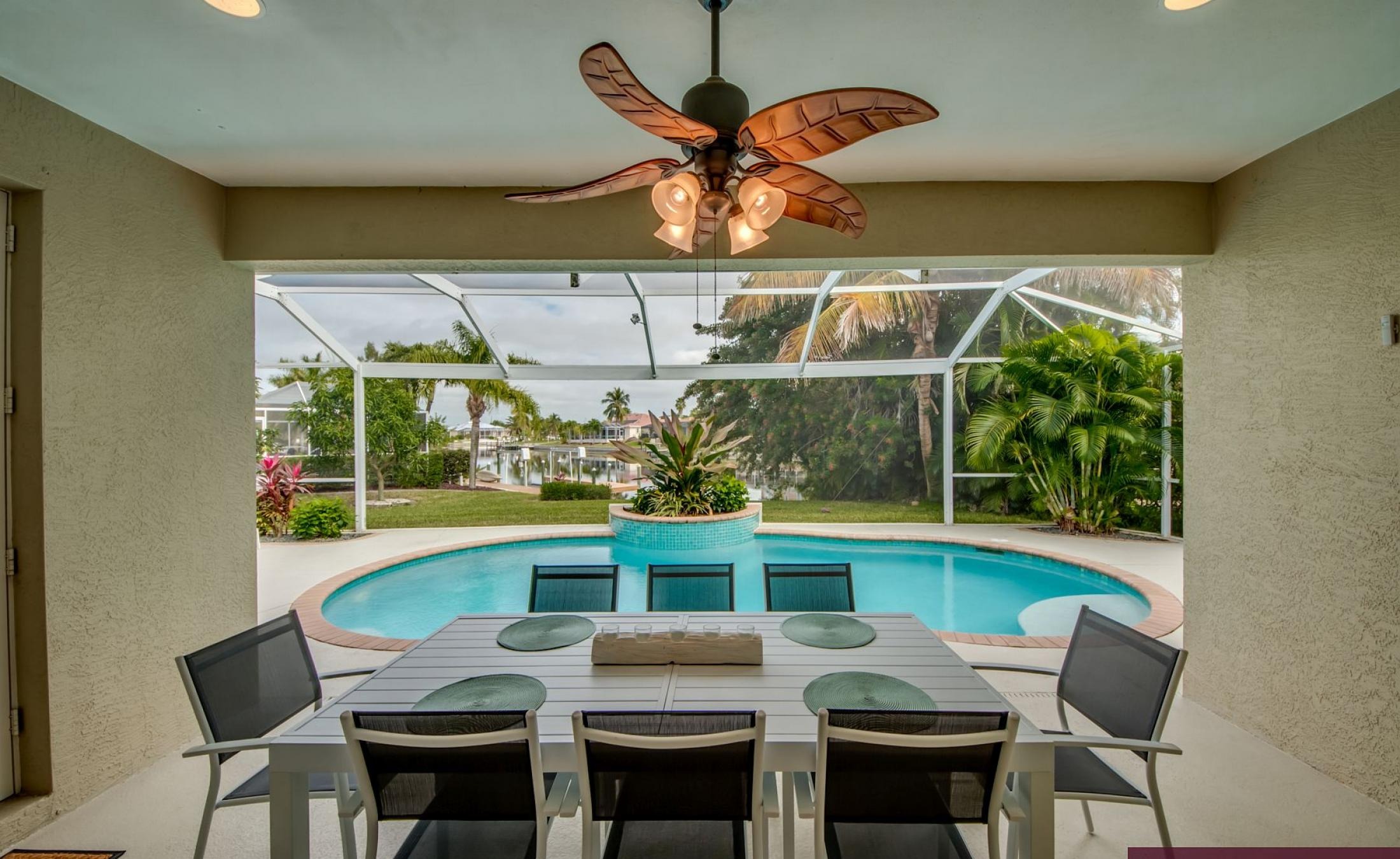 Elektrisch beheizter Pool mit Sonnenschirm und Strandstühlen am Wasserkanal.