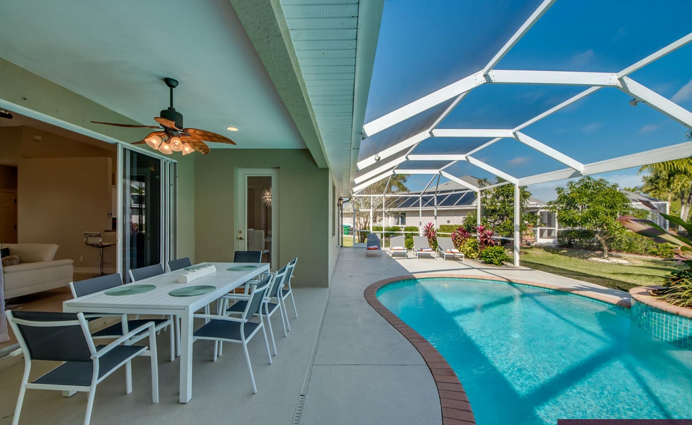 Elektrisch beheizter Pool mit Sonnenschirm und Strandstühlen am Wasserkanal.