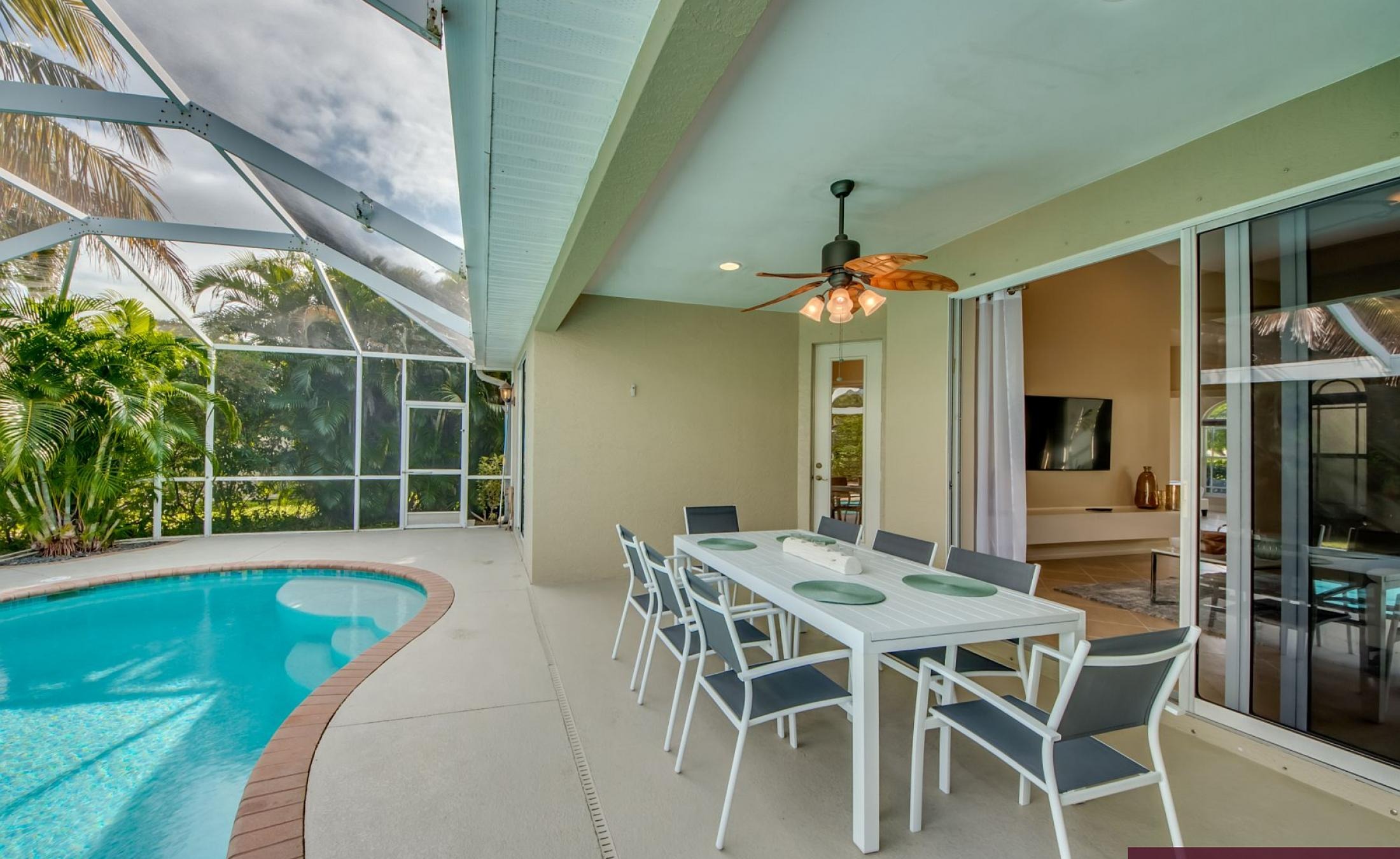 Elektrisch beheizter Pool mit Sonnenschirm und Strandstühlen am Wasserkanal.