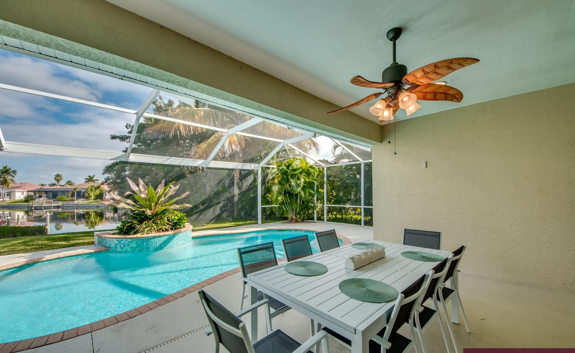 Beheizter Pool mit Sonnenschirm und Strandstühlen am Wasserkanal.