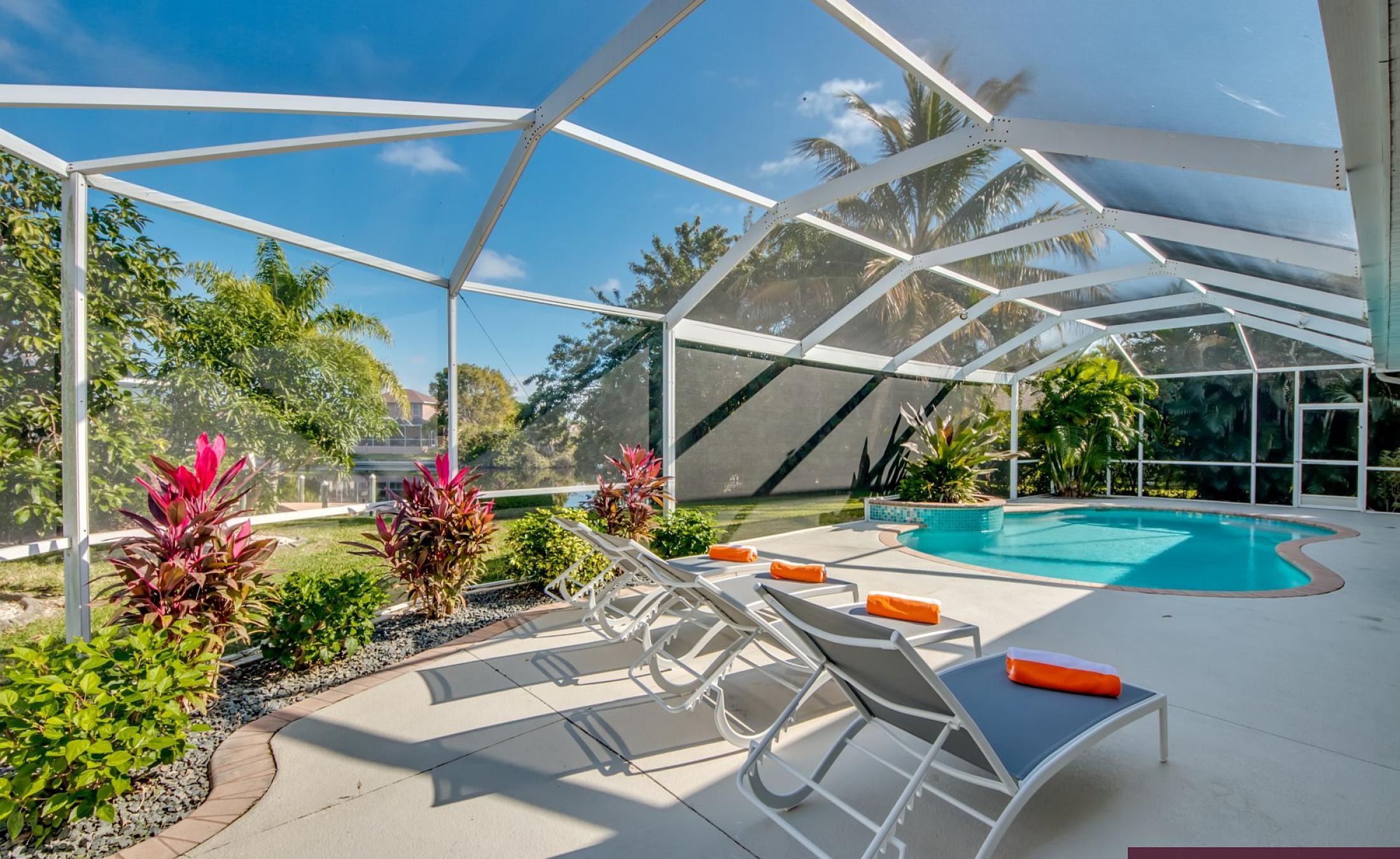 Elektrisch beheizter Pool mit Sonnenschirm und Strandstühlen am Kanal.