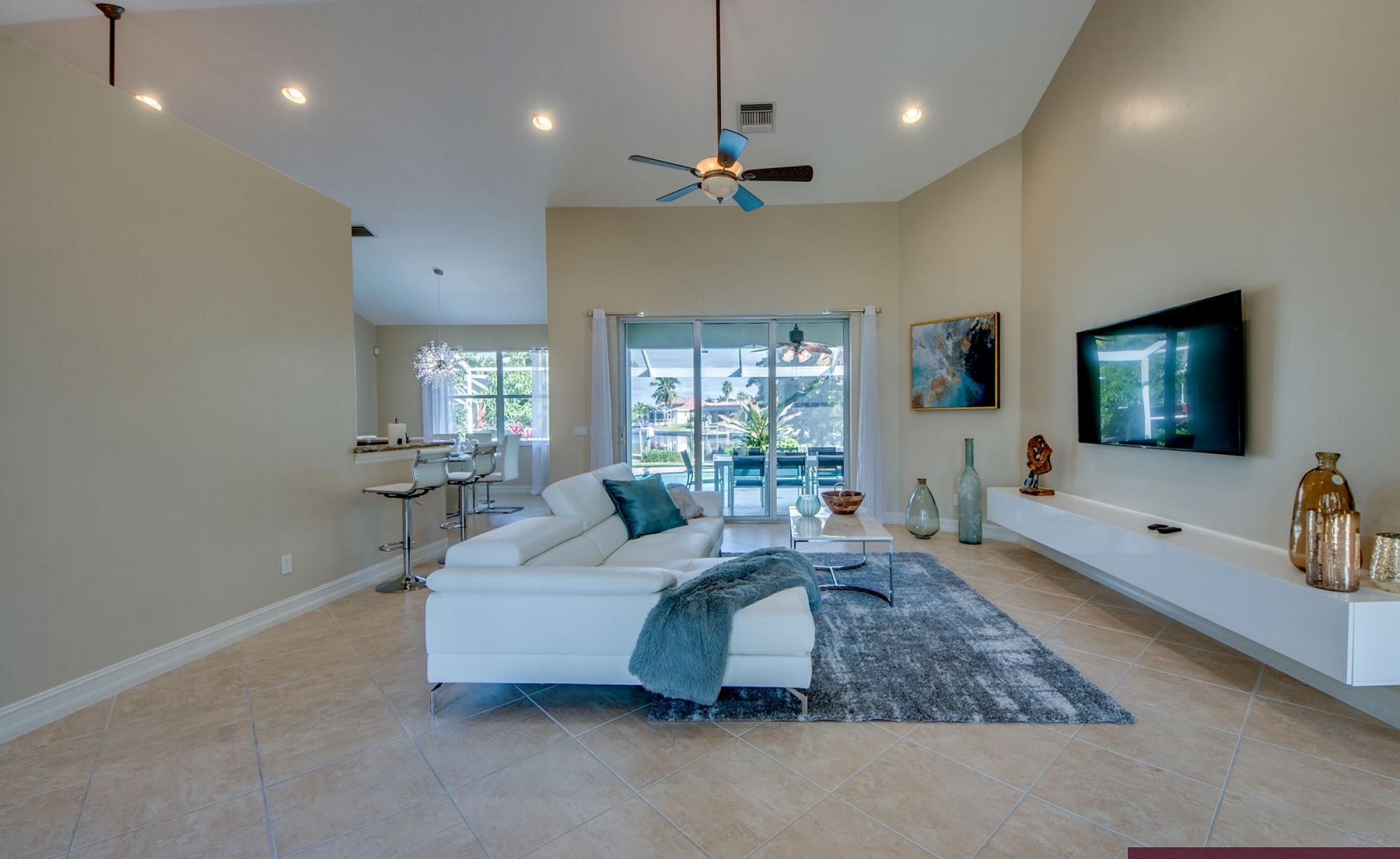 Elektrisch beheizter Pool mit Sonnenschirm und Strandstühlen am Wasserkanal.