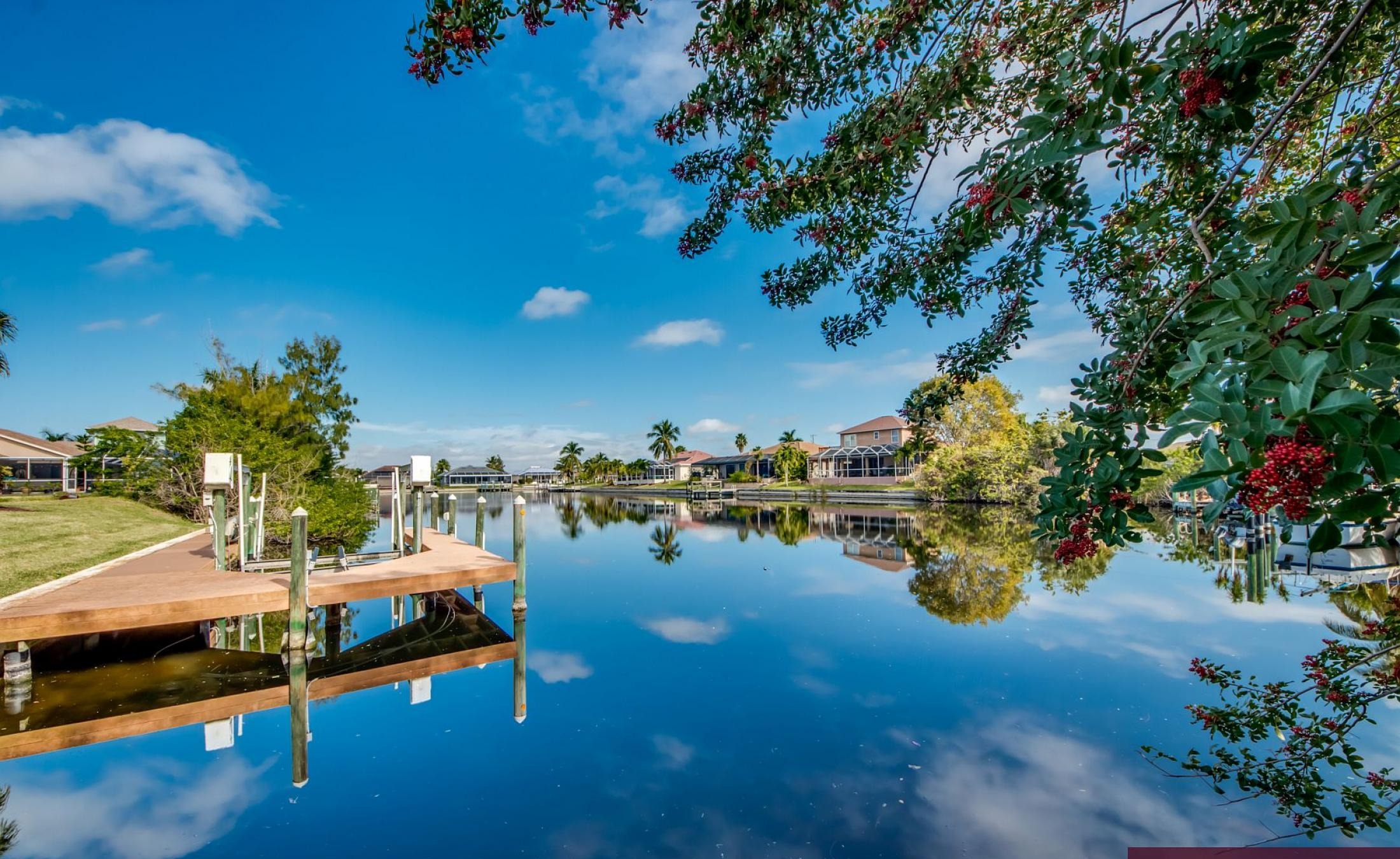 Beheizter Pool mit Sonnenschirm und Strandstühlen am Wasserkanal.