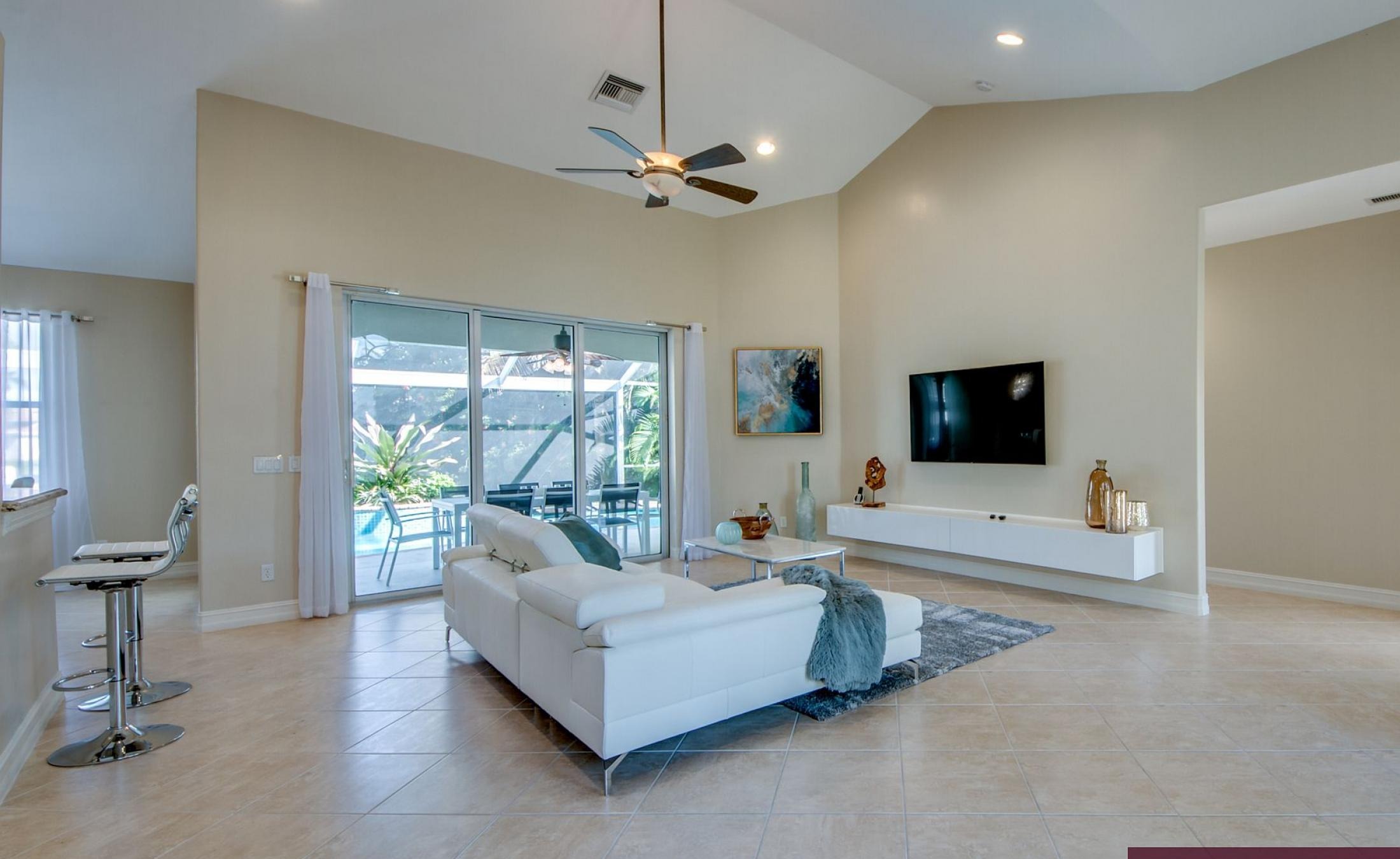 Beheizter Pool mit Sonnenschirm und Strandstühlen am Wasserkanal.