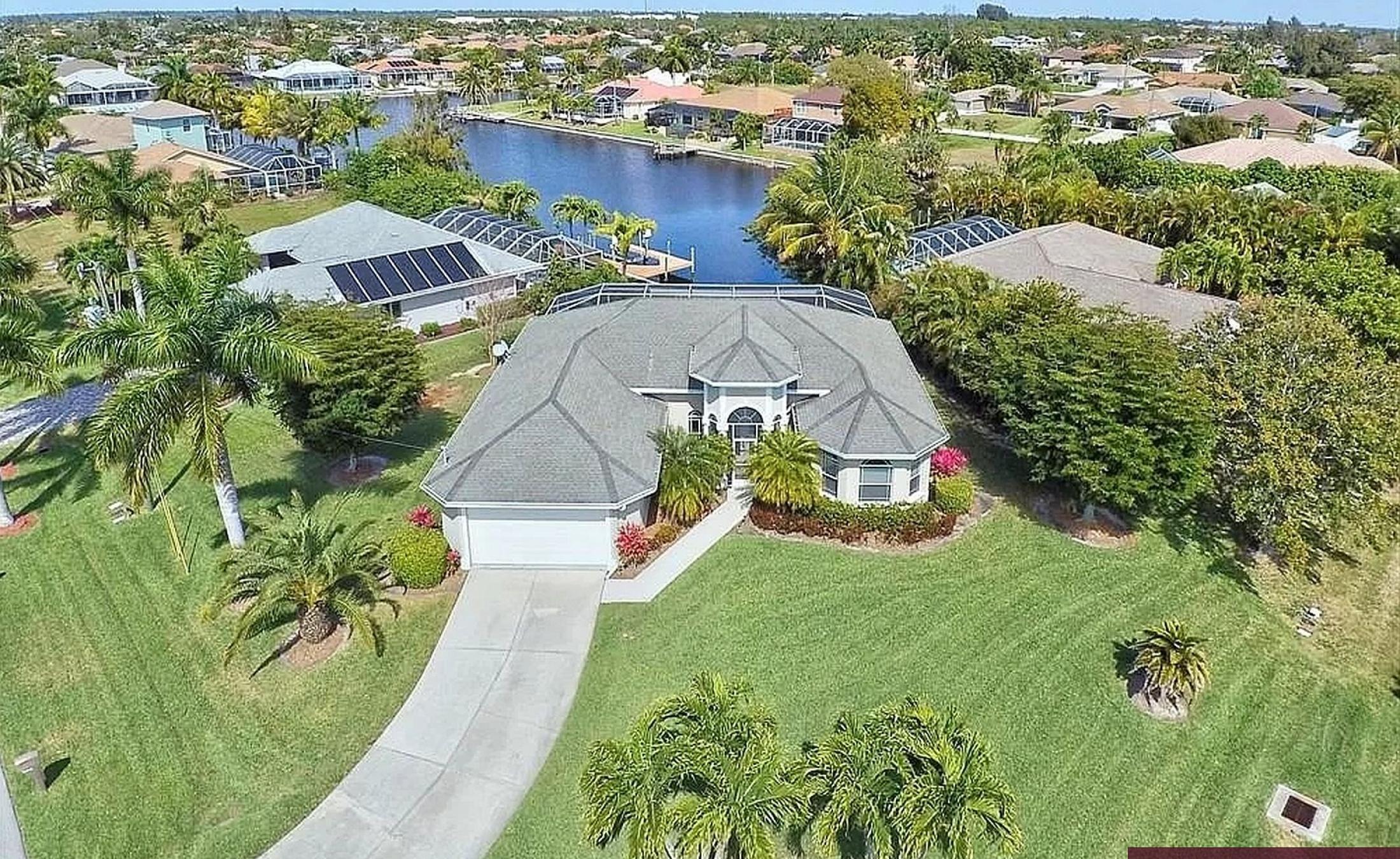 Elektrisch beheizter Pool mit Sonnenschirm und Strandstühlen am Wasserkanal.