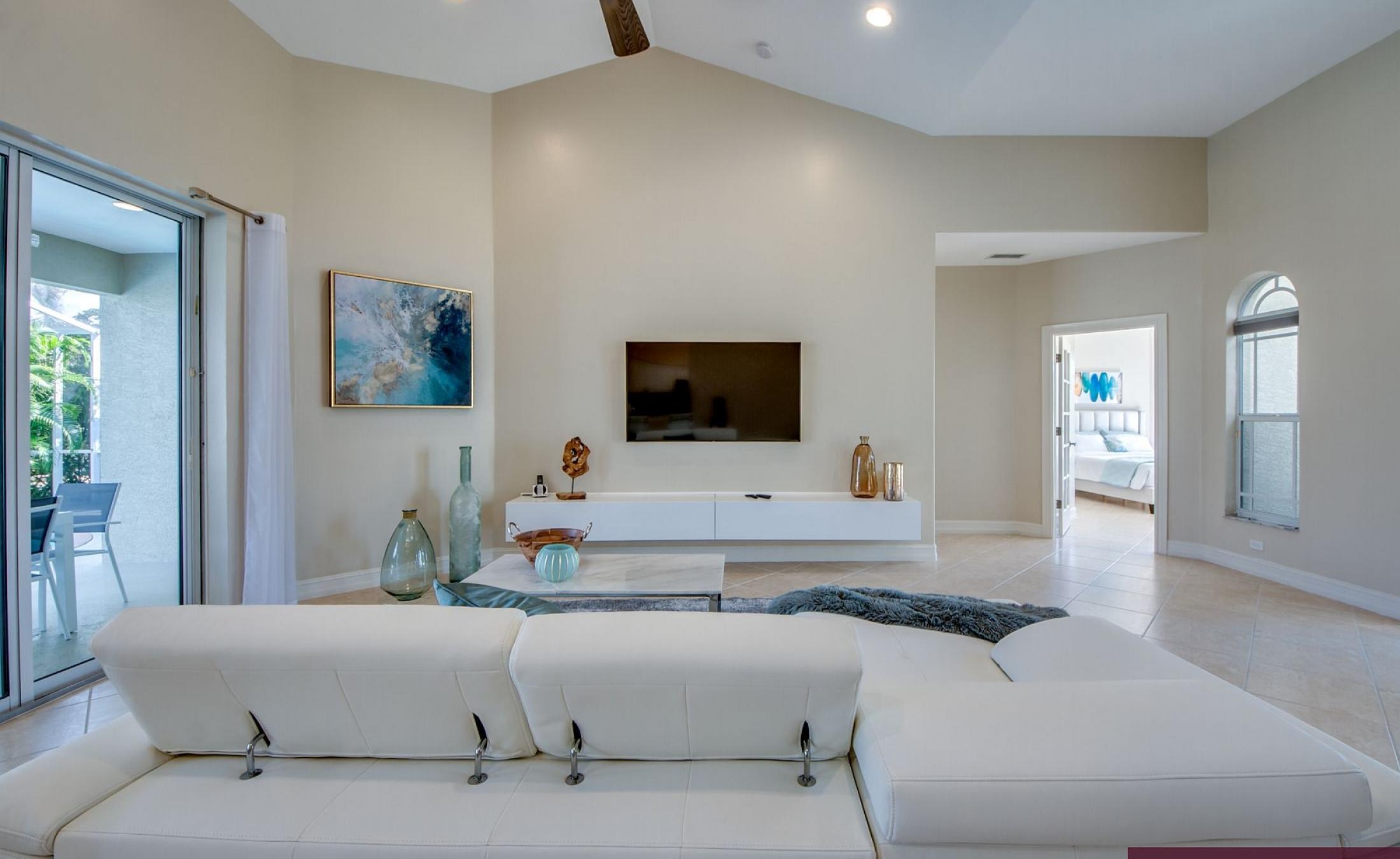 Elektrisch beheizter Pool mit Sonnenschirm und Strandstühlen am Wasserkanal.