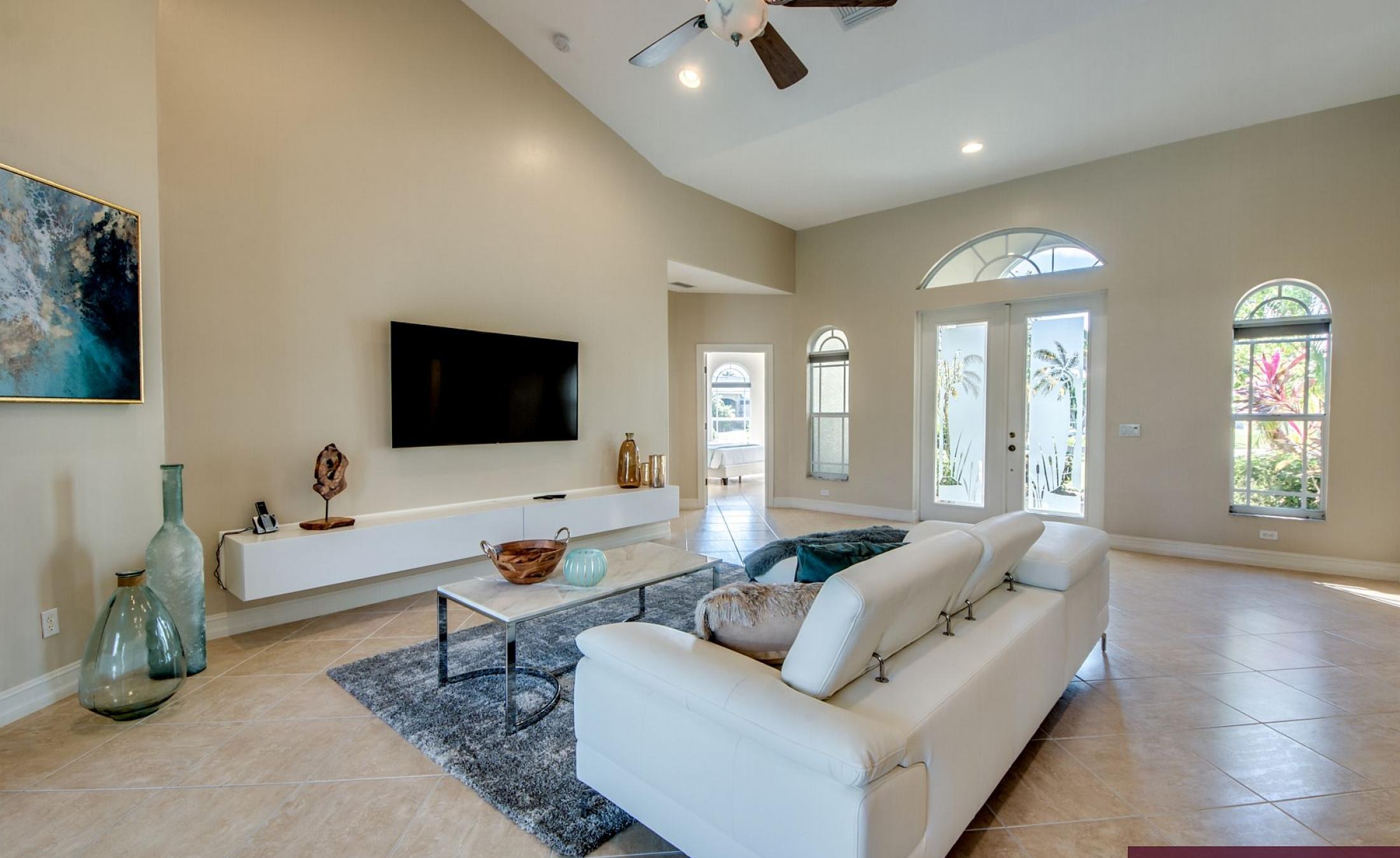 Beheizter Pool mit Sonnenschirm und Strandstühlen am Wasserkanal.