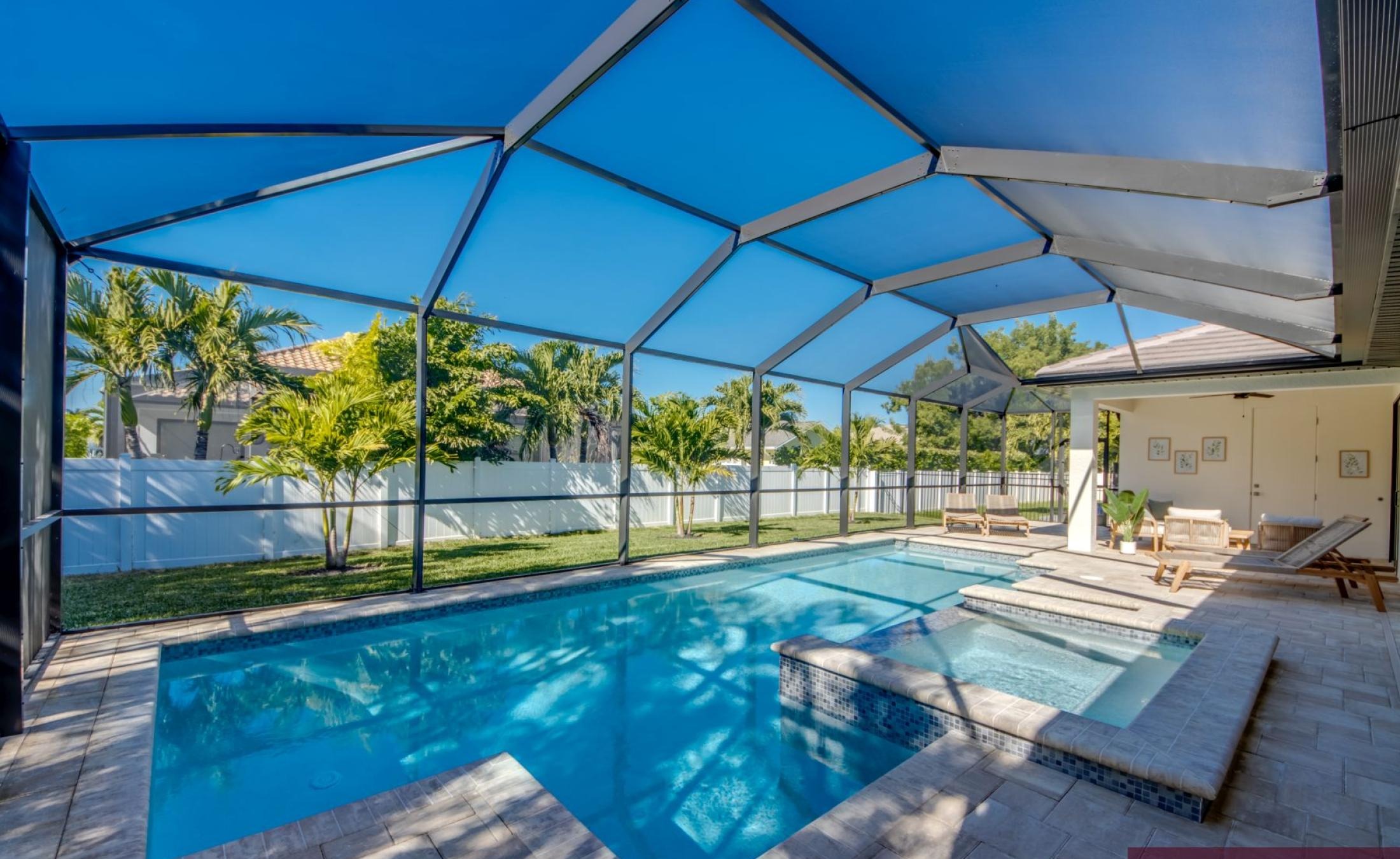 Beheizter Pool mit integriertem Jacuzzi und Sonnenliegen auf der Terrasse.