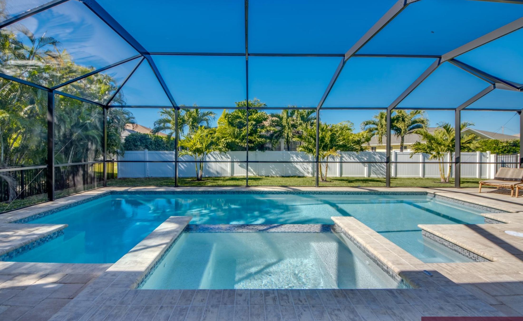 Beheizter Pool mit integriertem Jacuzzi auf sonniger Terrasse.