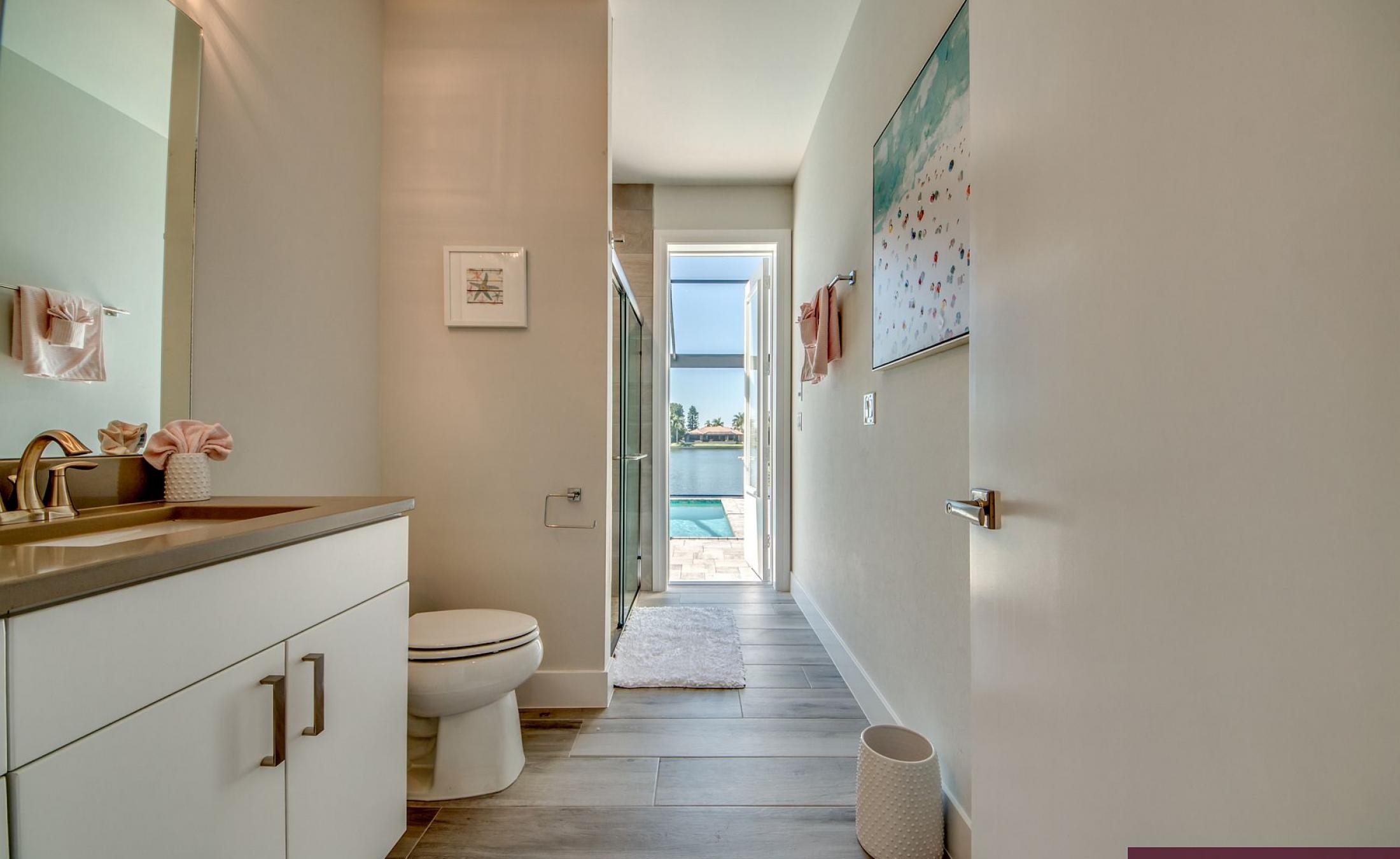 Beheizter Pool mit Sunledge und Liegen am Seeufer.