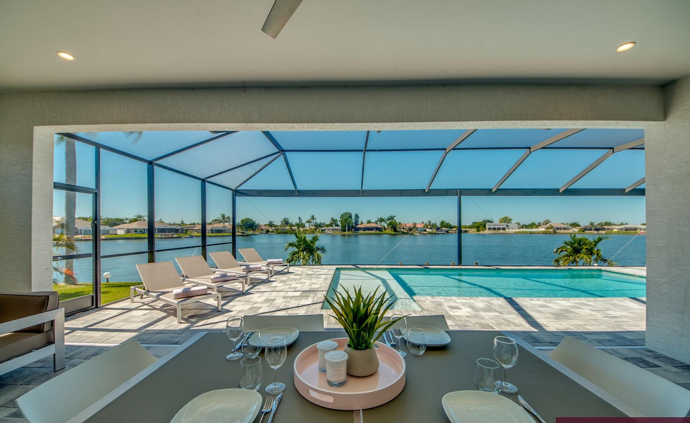 Beheizter Pool mit Sunledge und Liegen am Seeufer.